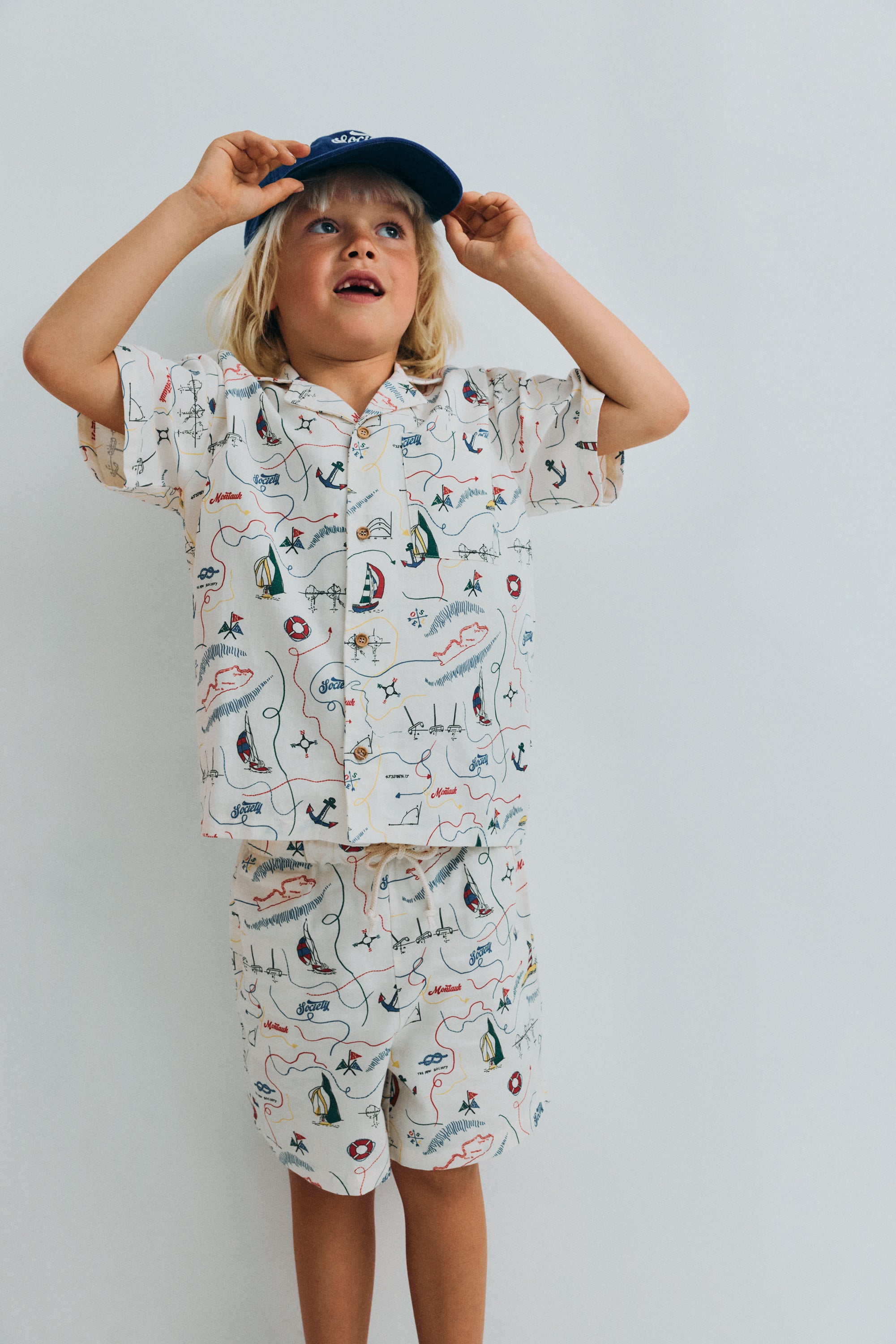 Short sleeve shirt in&nbsp;soft cotton featuring a unique multicolor map print and a front button closure with wooden buttons. 