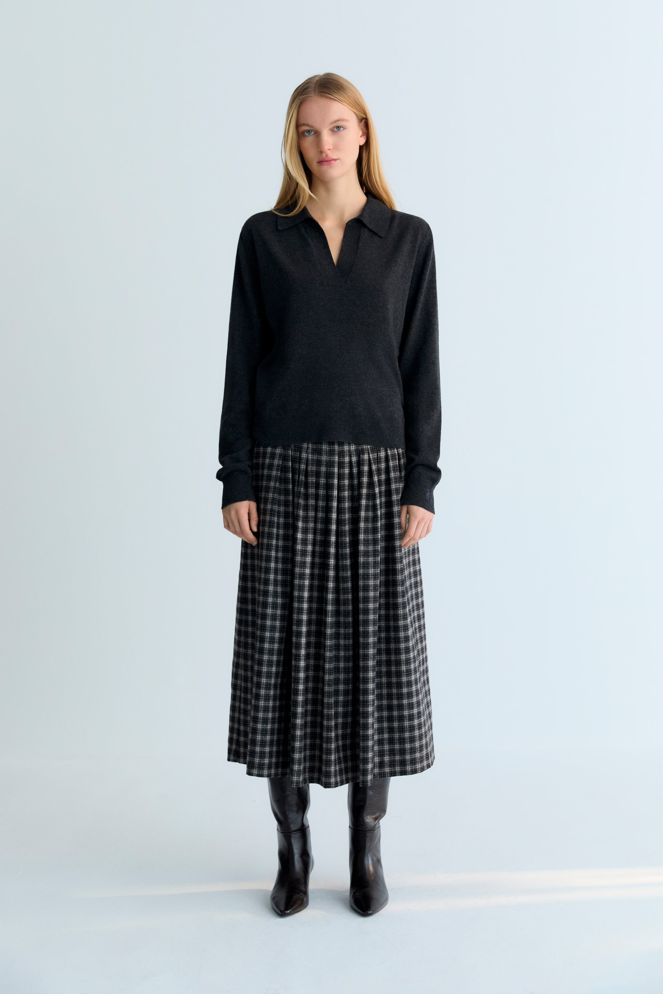 Midi A-line wool plaid skirt with stitched pleat detail on the top. It has a zipper on the side.