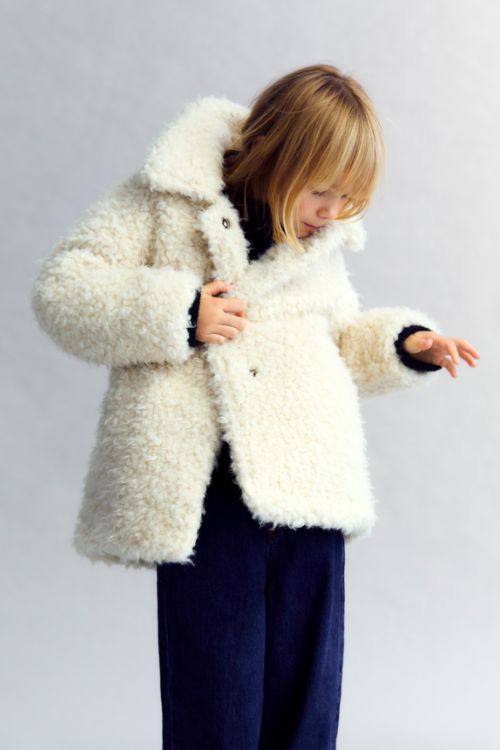 Girl wearing The New Society Ninette Girl Coat in Moonlight White with snap-front closure and recycled faux-fur finish, from the AW25 collection