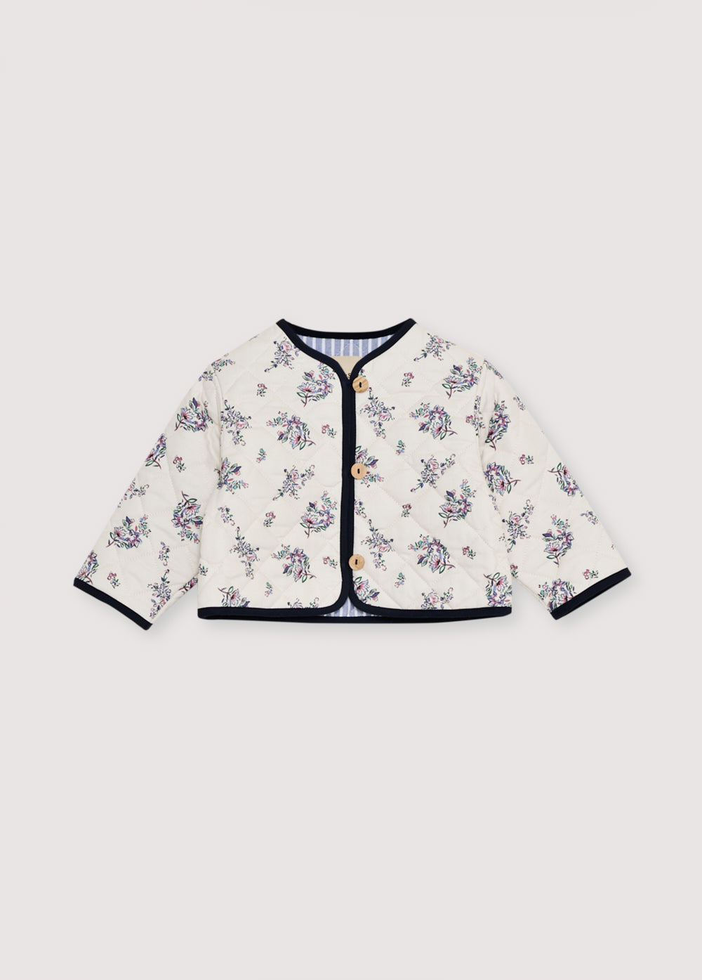Quilted jacket with a floral print exterior and contrasting striped interior. It loses with wooden buttons.