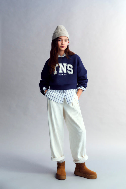 Crop-style sweater with puffed sleeves and a brand patch on the front. Brushed on the inside and outside.