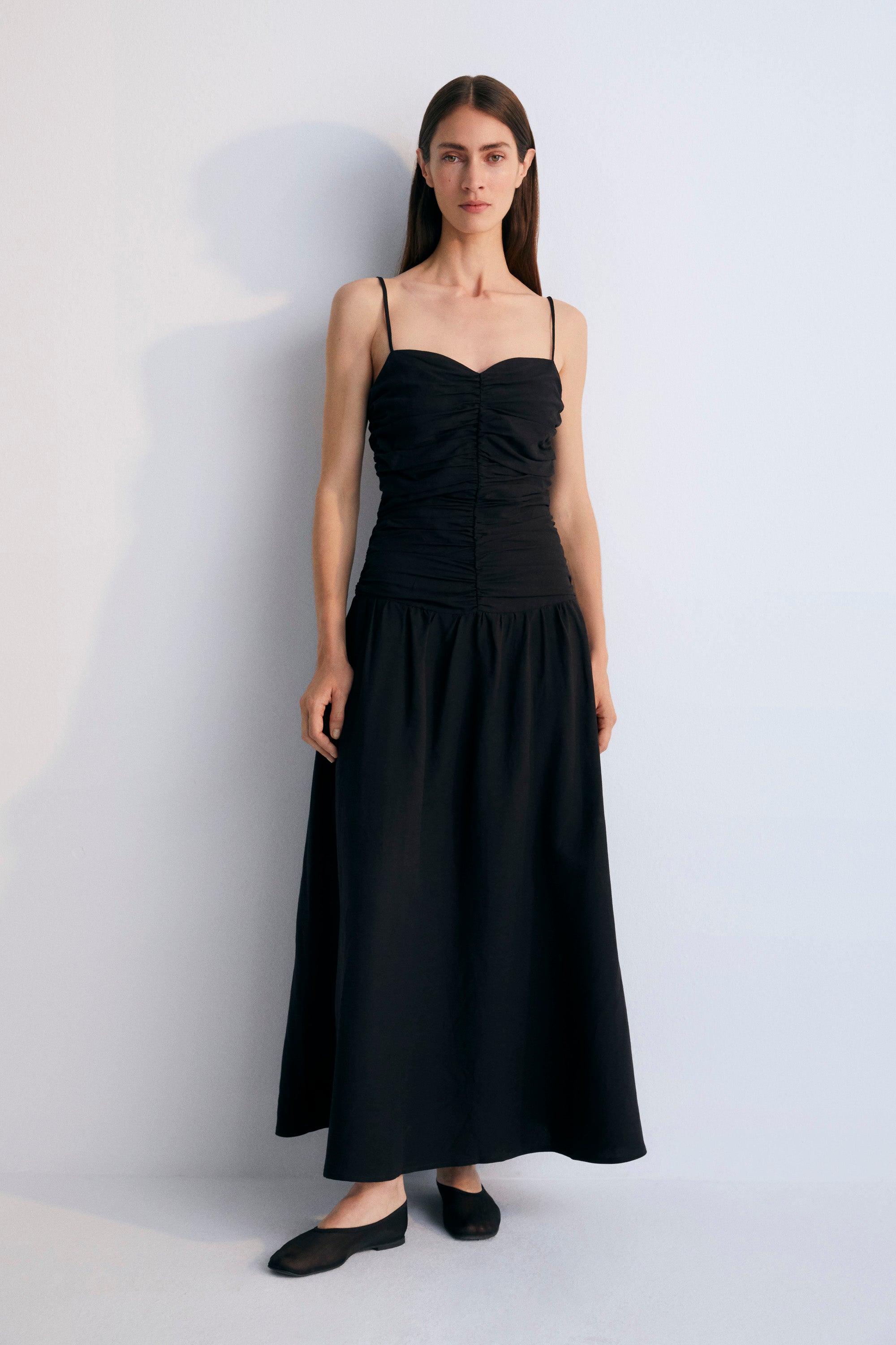 Long dress with gathering on the front and back bodice. It has thin straps with adjusters and an invisible zipper on the side. Woman Collection. The New Society