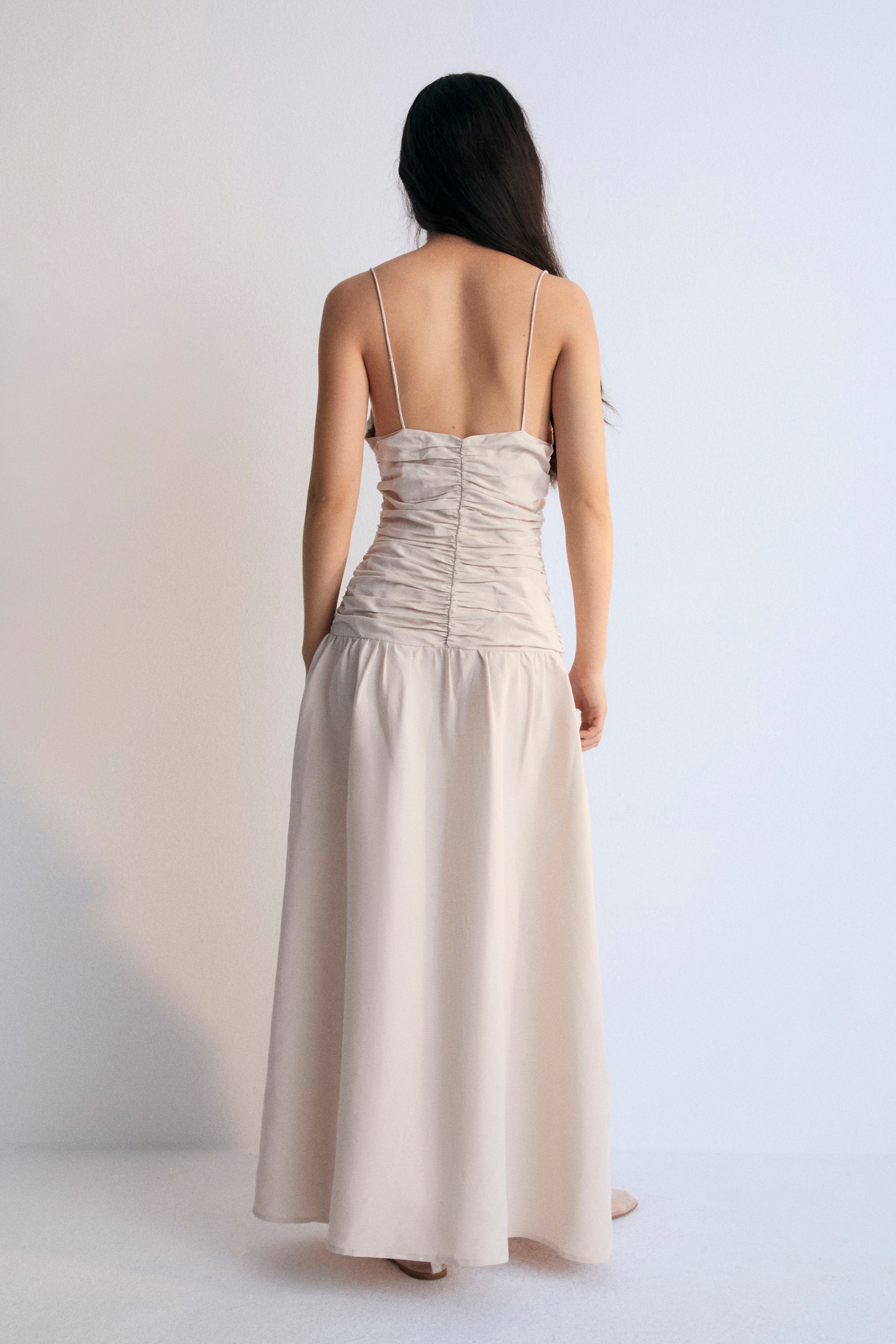 Long dress with gathering on the front and back bodice. It has thin straps with adjusters and an invisible zipper on the side. The New Society.