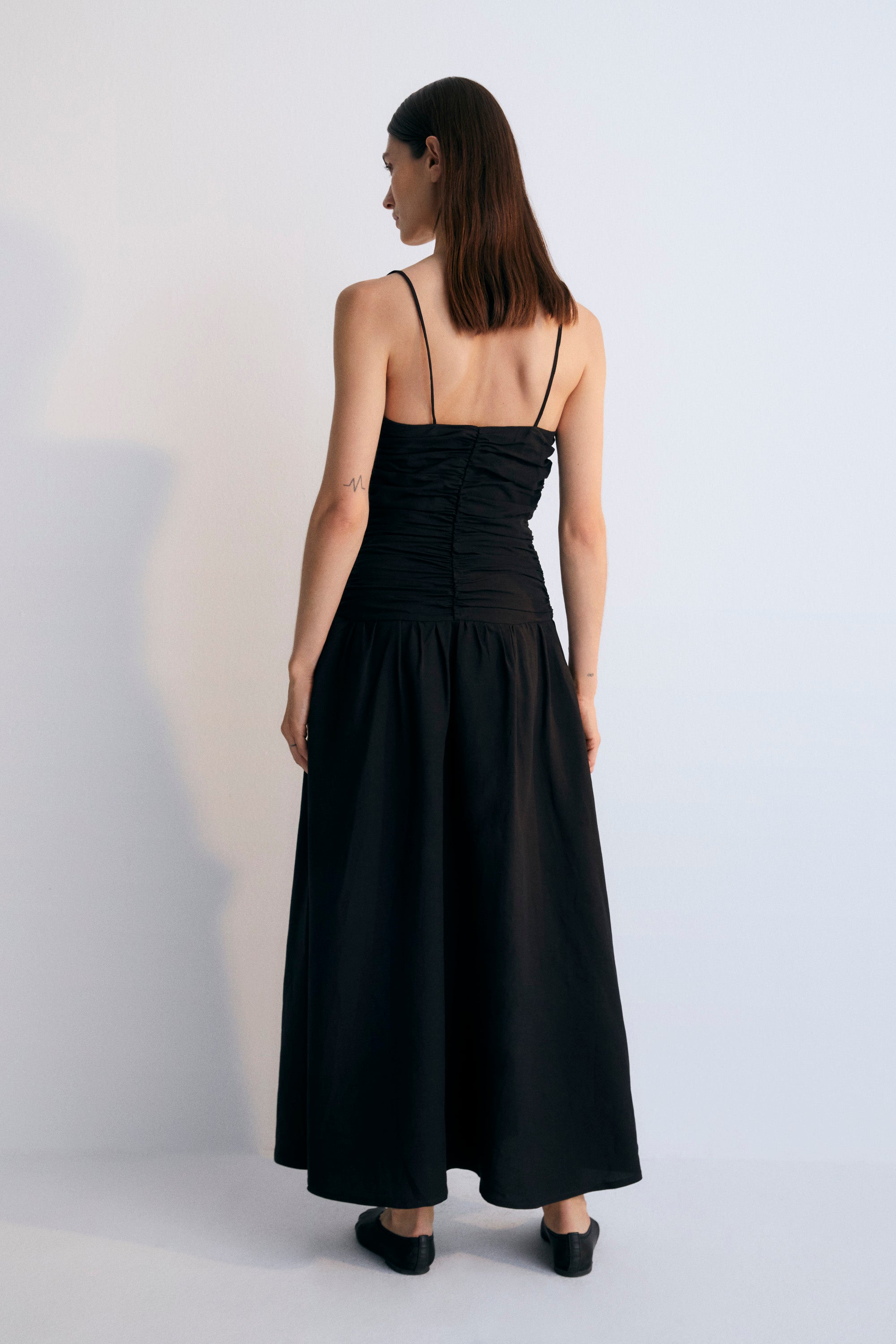 Long dress with gathering on the front and back bodice. It has thin straps with adjusters and an invisible zipper on the side. Woman Collection. The New Society