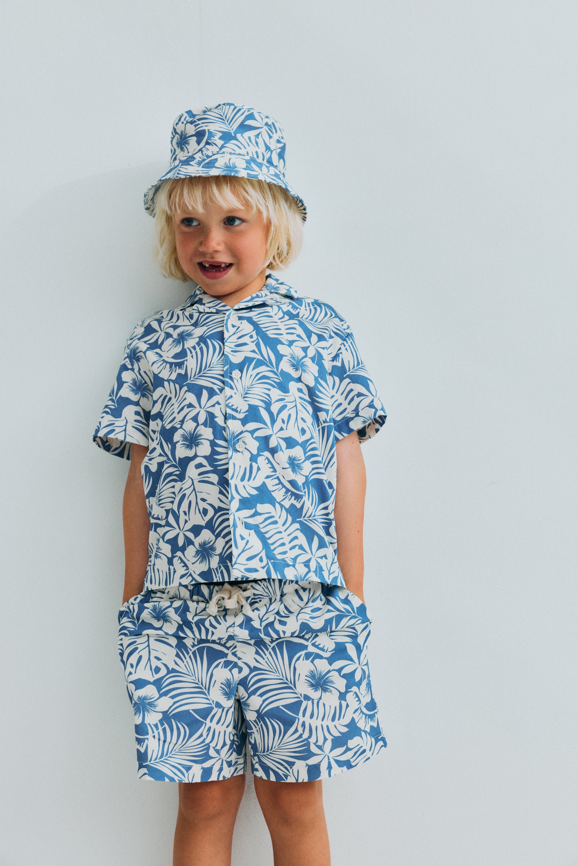 This short-sleeve shirt for kids is crafted from soft, breathable cotton, designed to keep little ones comfortable throughout the warmer days.