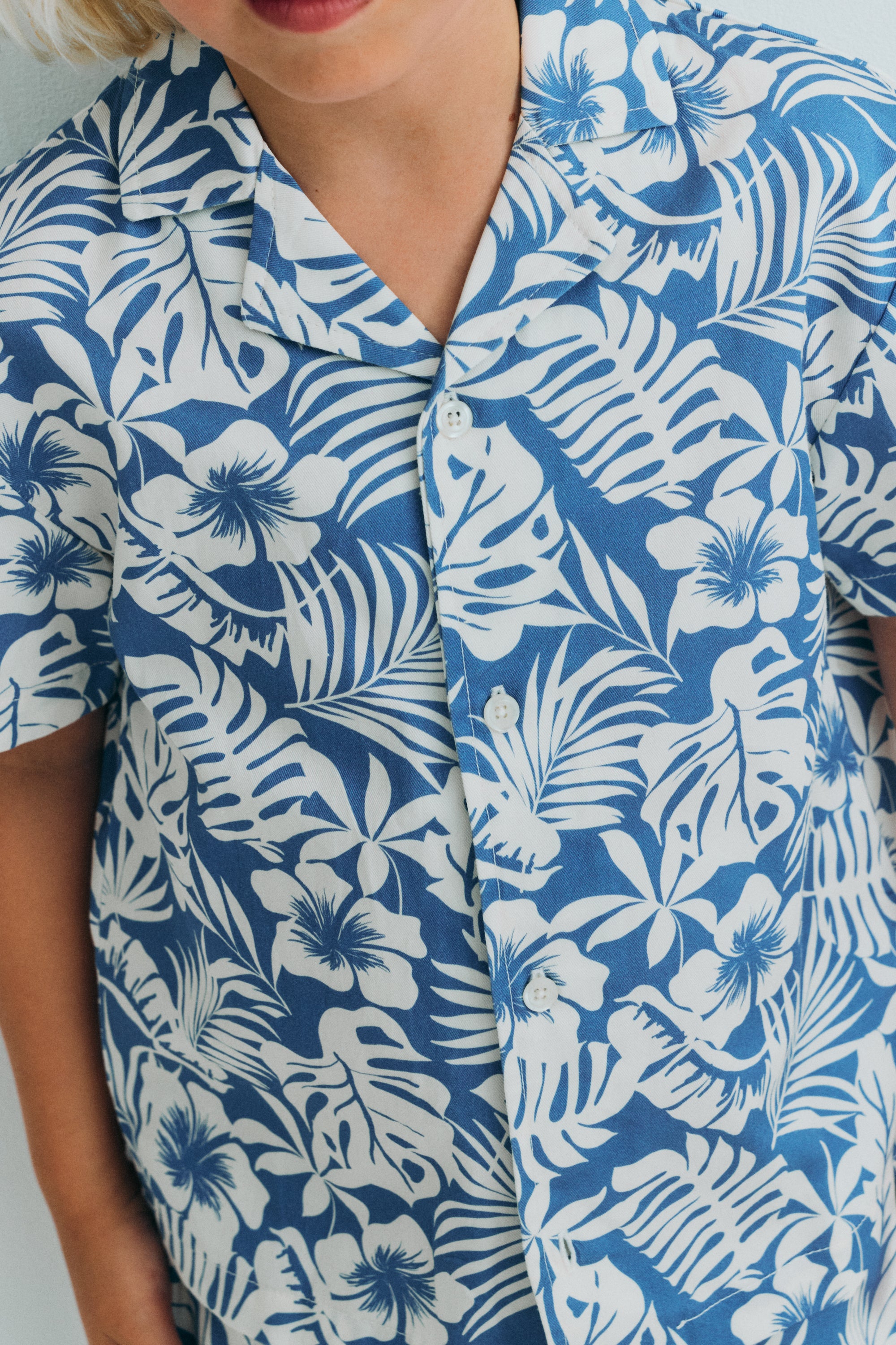 This short-sleeve shirt for kids is crafted from soft, breathable cotton, designed to keep little ones comfortable throughout the warmer days.