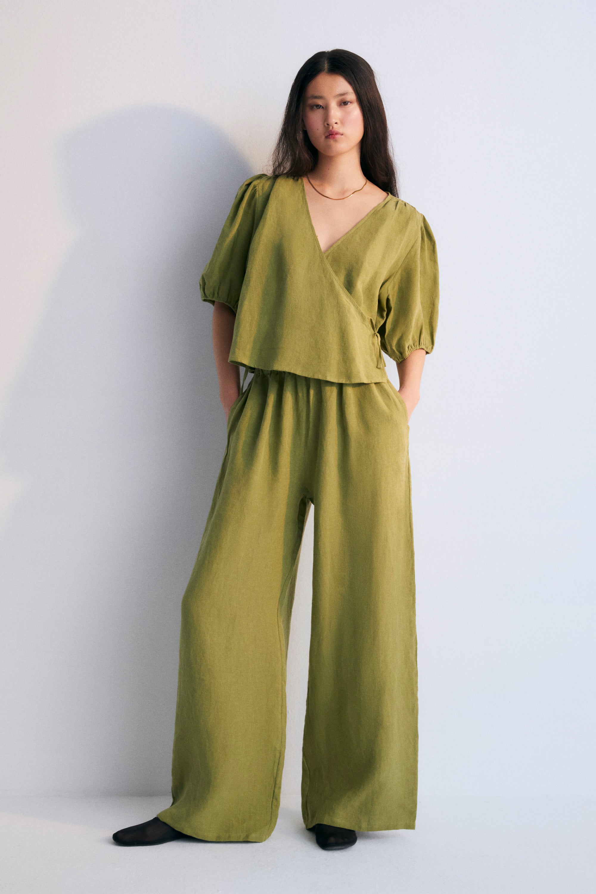 Hera Woman Pant in 100% linen, available in three colors: caviar, macadamia, and olive, to complete the total look with blouse and coat. Straight-leg pants with elastic waistband and side pockets.