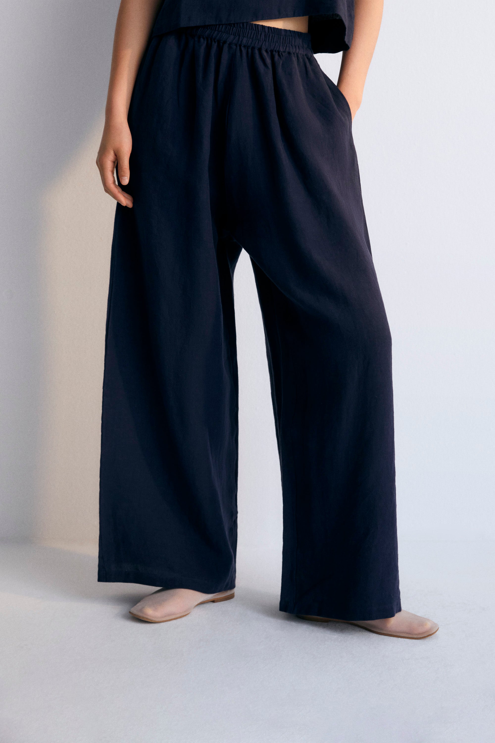 Hera Woman Pant in 100% linen, available in three colors: caviar, macadamia, and olive, to complete the total look with blouse and coat. Straight-leg pants with elastic waistband and side pockets.