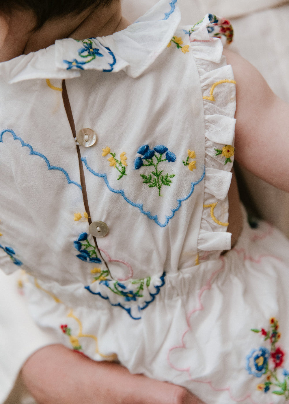 Pelele para bebé confeccionado en 100% algodón, que presenta un especial y delicado bordado floral multicolor por toda la prenda.