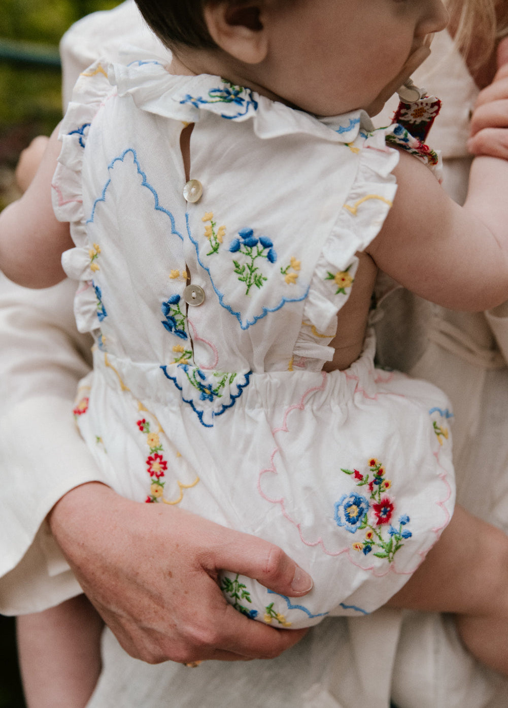 Pelele para bebé confeccionado en 100% algodón, que presenta un especial y delicado bordado floral multicolor por toda la prenda.