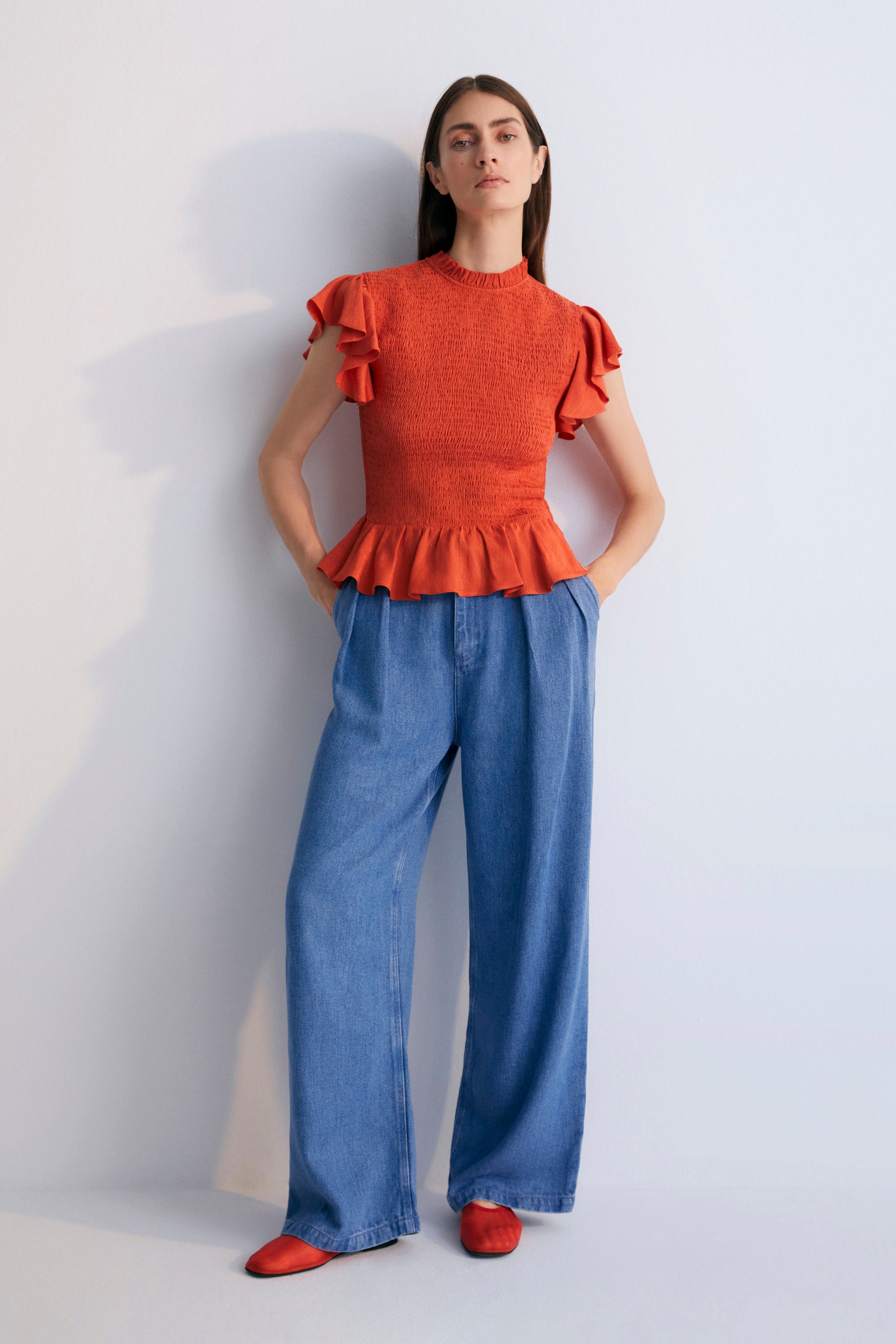 Jacquard woven blouse in a lovely chili color with smocking on the body and ruffles at the waist and shoulders.