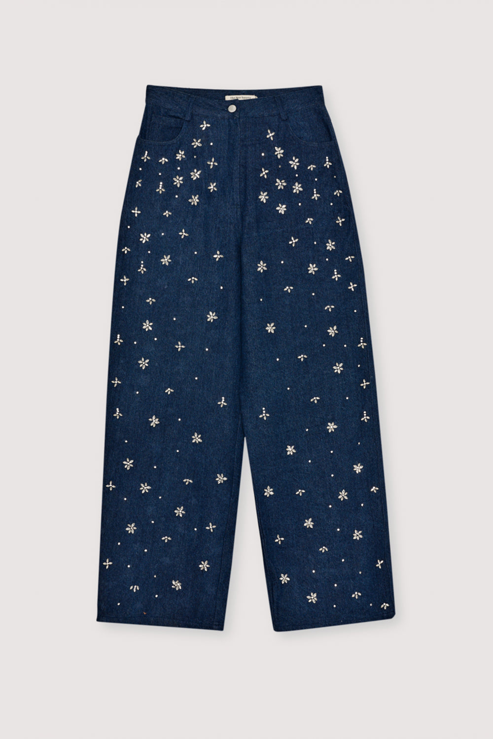Wide-leg denim pant with delicate hand-applied crystal details at the front. It features patch pockets at the back and TNS embroidery on the waistband.