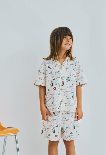 Short sleeve shirt in soft cotton featuring a unique multicolor map print and a front button closure with wooden buttons. 