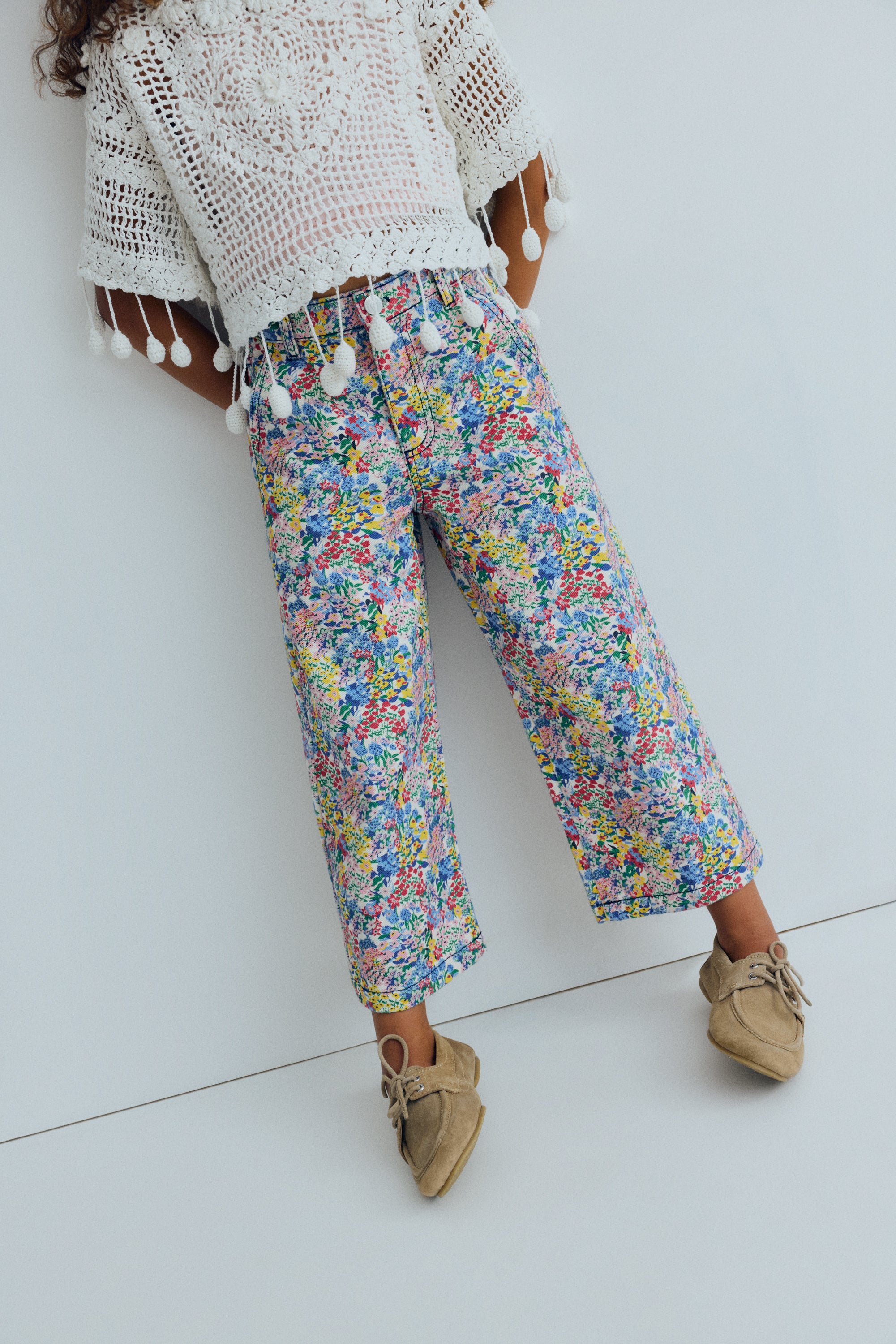 Wide leg denim pants featuring a beautiful flower print, straight legs, and an adjustable waistband with interior elastic