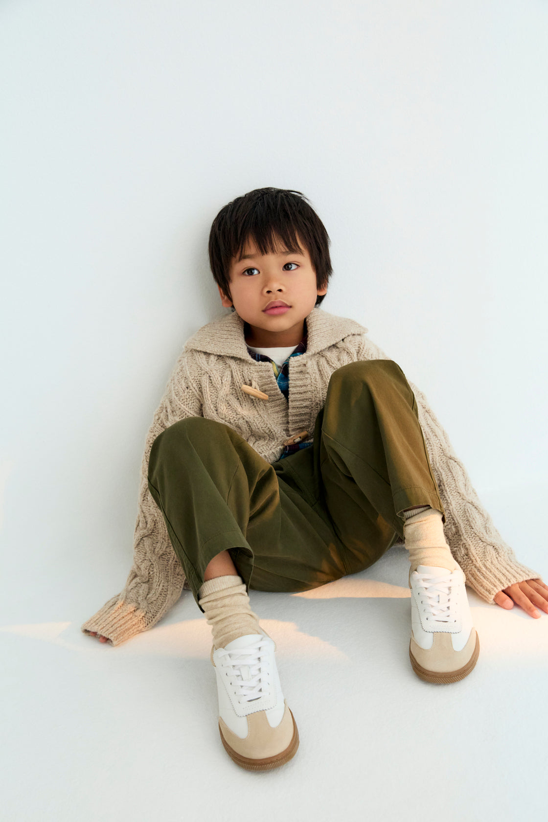 Knitted cardigan with a ribbed collar, cuffs, and hem. Features a front opening with wooden toggles. Made with recycled wool.