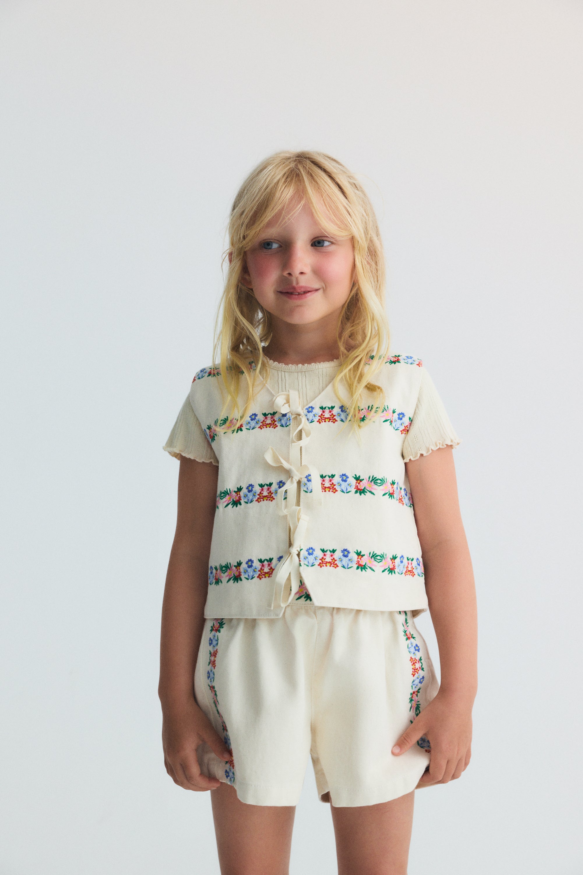 Steppweste für Kinder aus BCI-Baumwolldenim mit zarten und schönen Stickereidetails auf der Vorder- und Rückseite.