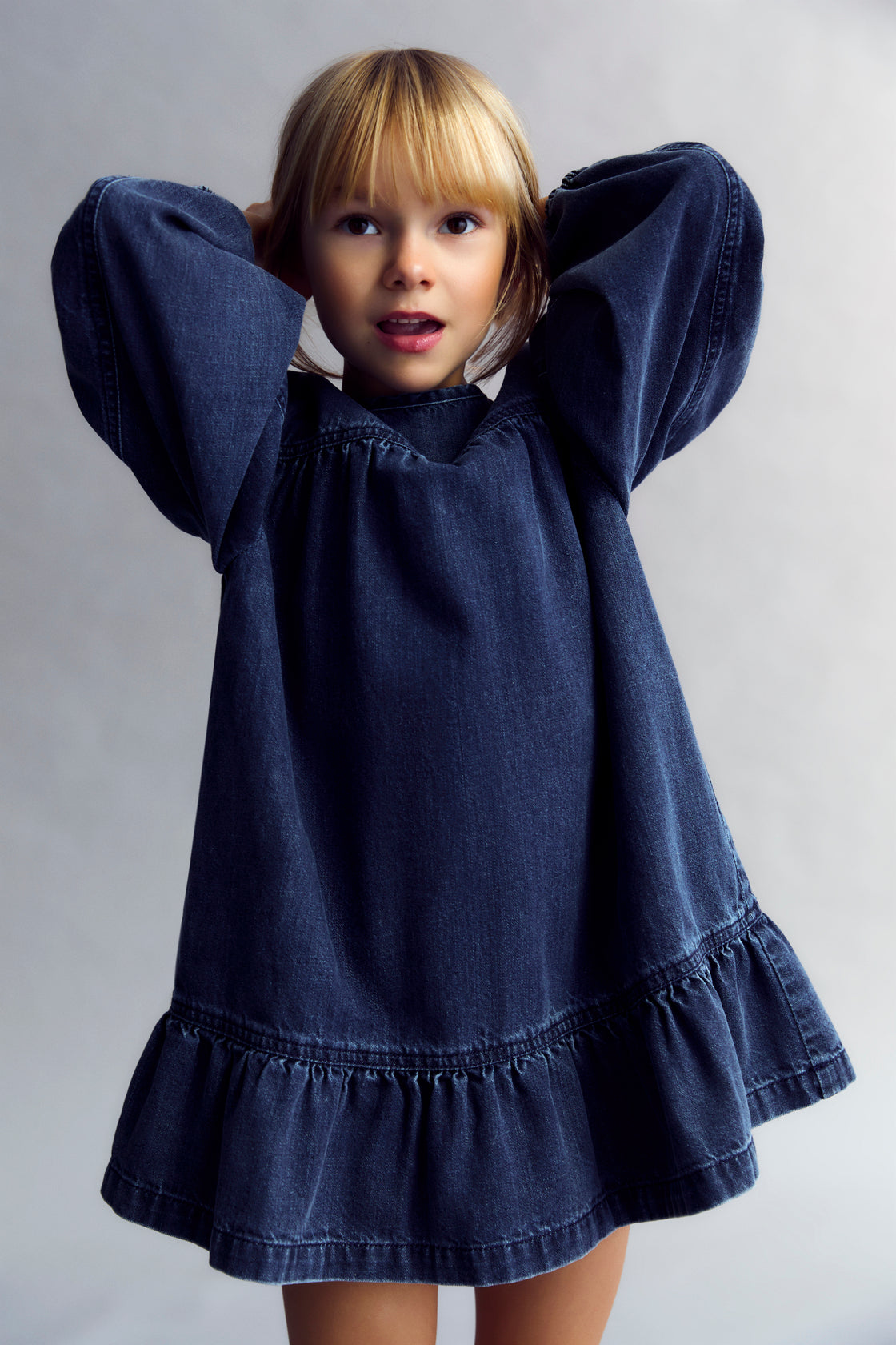 Short washed dark denim dress featuring puffed sleeves and a back cut-out detail. TNS embroidery.