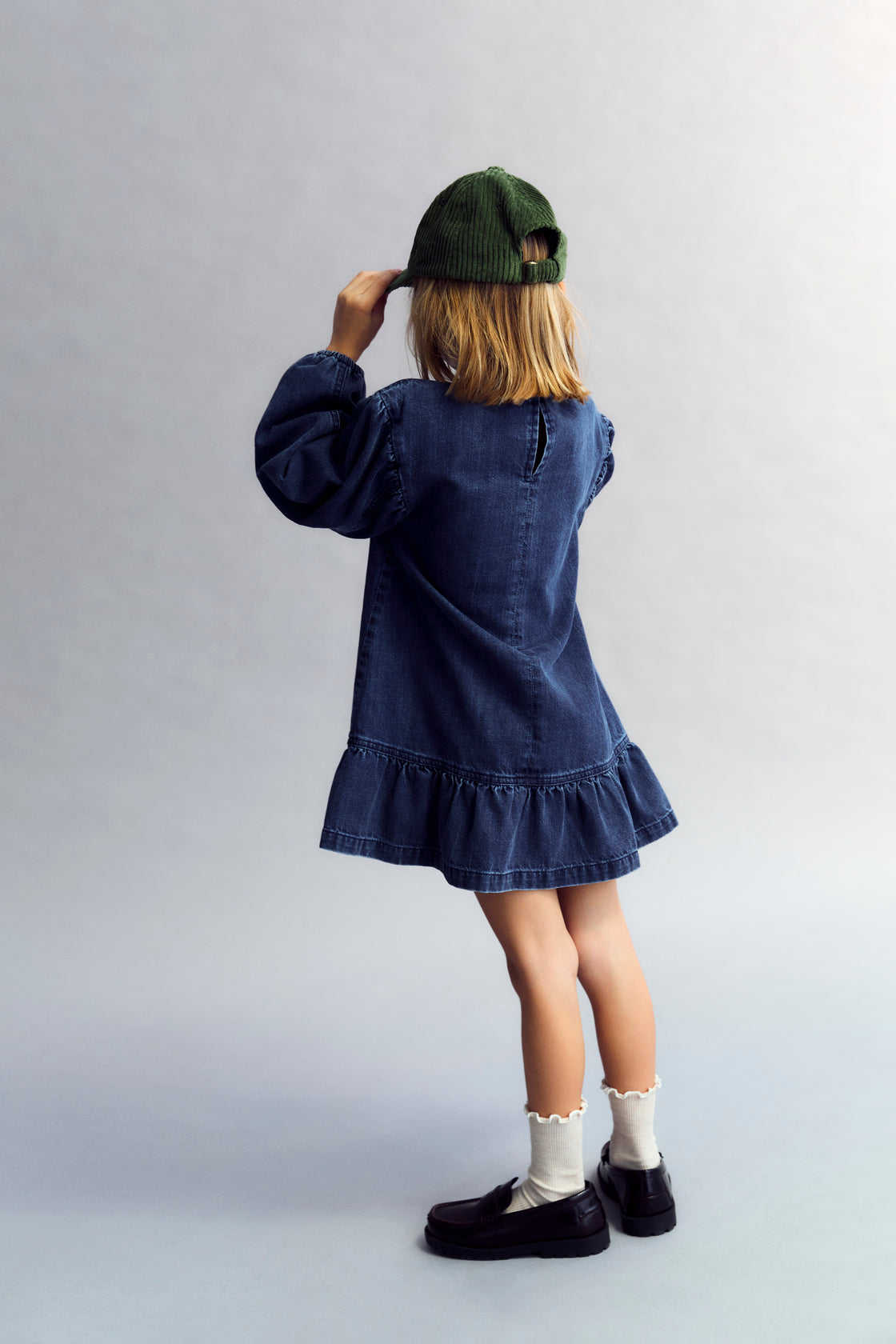 Short washed dark denim dress featuring puffed sleeves and a back cut-out detail. TNS embroidery.