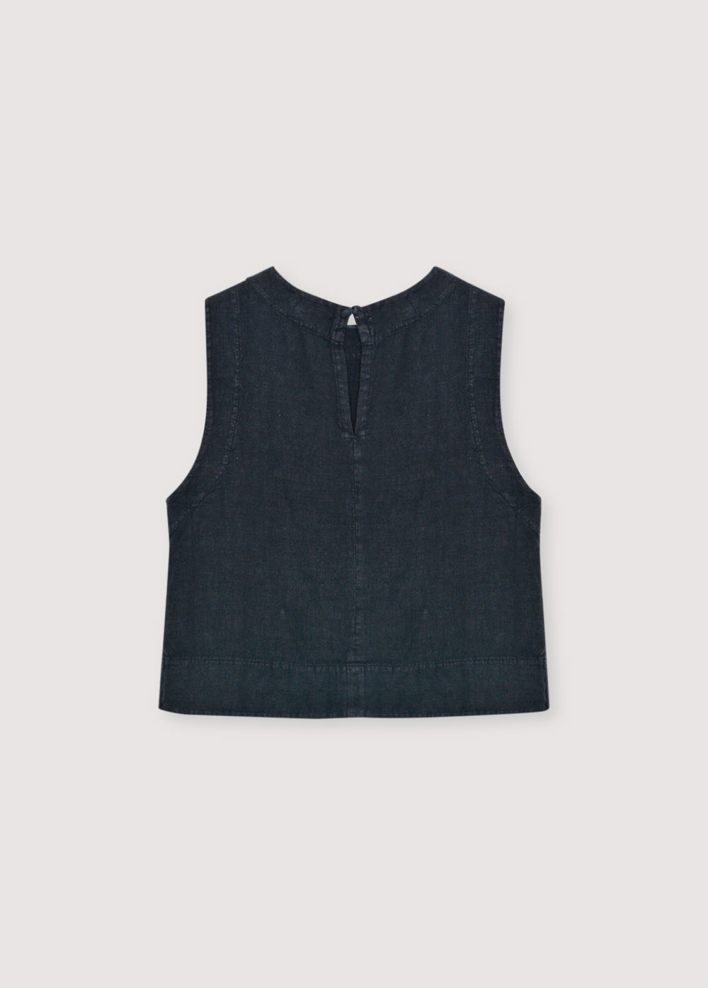 Linen top with a soft, delicate finish, crafted in Portugal. Features a back keyhole opening with button closure and is available in various colours, perfect to pair with other pieces from the collection.