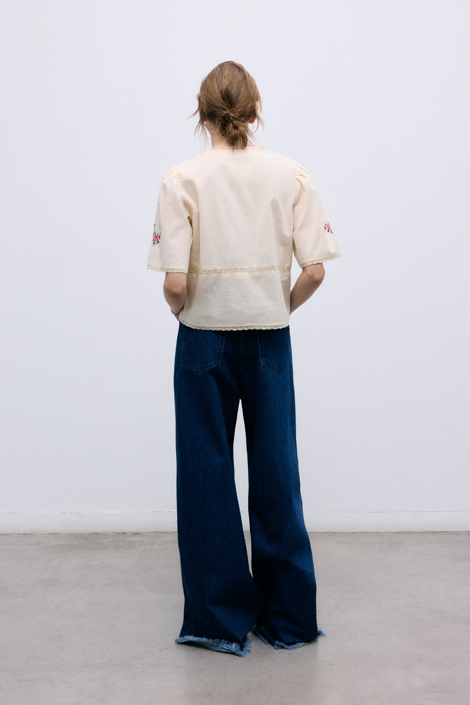 Crafted from soft 100% cotton, this blouse features a flattering V-neckline and a front opening with delicate tie closures.