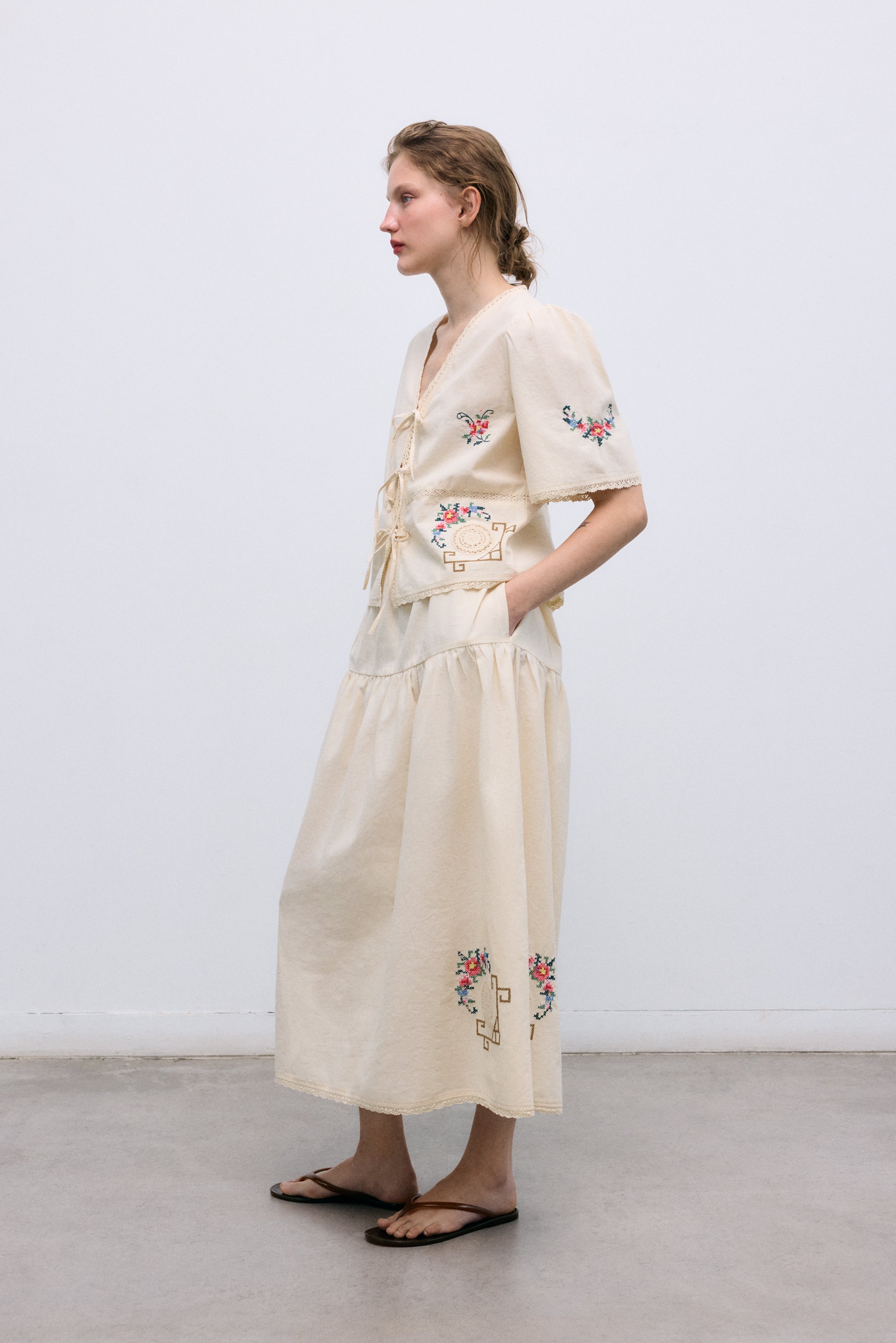 Crafted from soft 100% cotton, this blouse features a flattering V-neckline and a front opening with delicate tie closures.