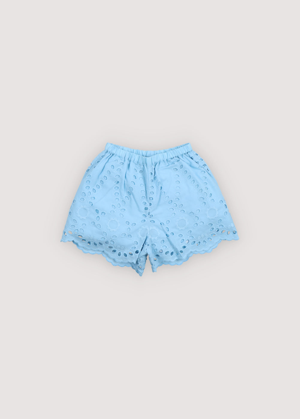 Patmos Short in embroidered voile fabric, 100% cotton, in powder blue color, featuring central buttons, elastic waistband with ruffle detail, and embroidered fabric finishing on the hem. Spring Summer Collection. The New Society. 