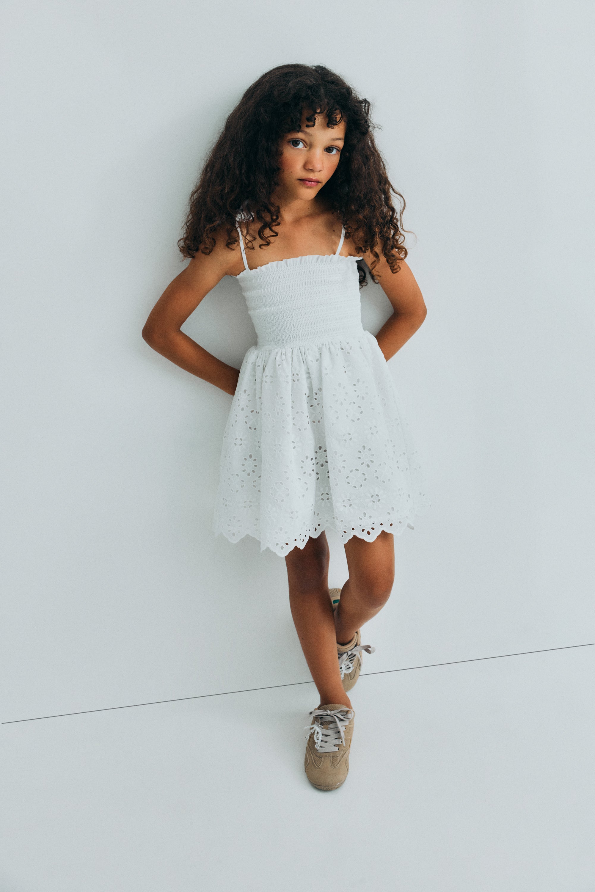 Short dress in beautiful embroidered cotton fabric, featuring a smocked bodice with ruffle detail for a comfortable and flattering fit.