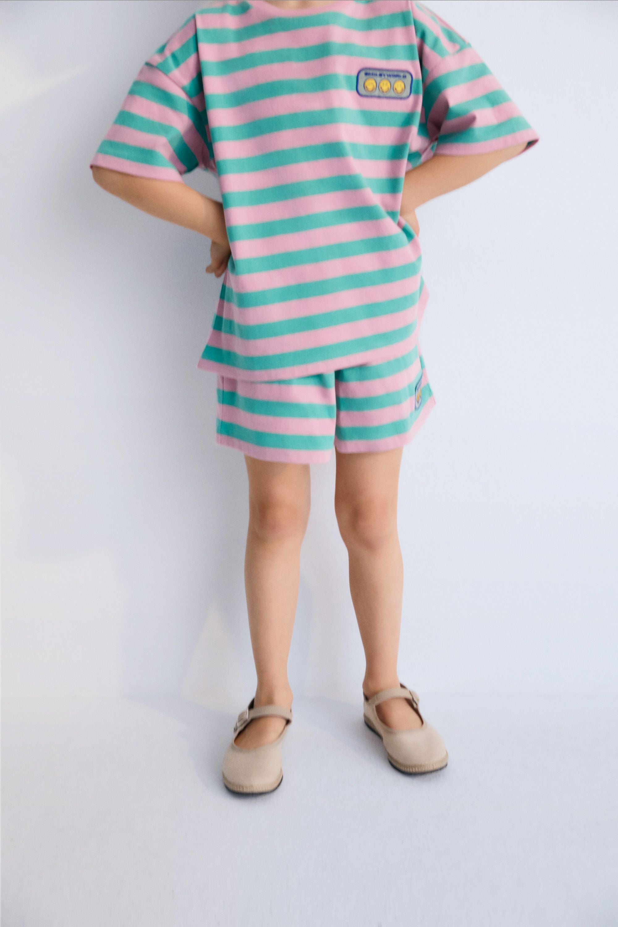 Shorts with fun bicolor stripes, elastic waistband with a drawstring, and a matching SMILEYWORLD patch. Perfect to combine with the matching T-shirt. Spring Summer Collection. The New Society. 