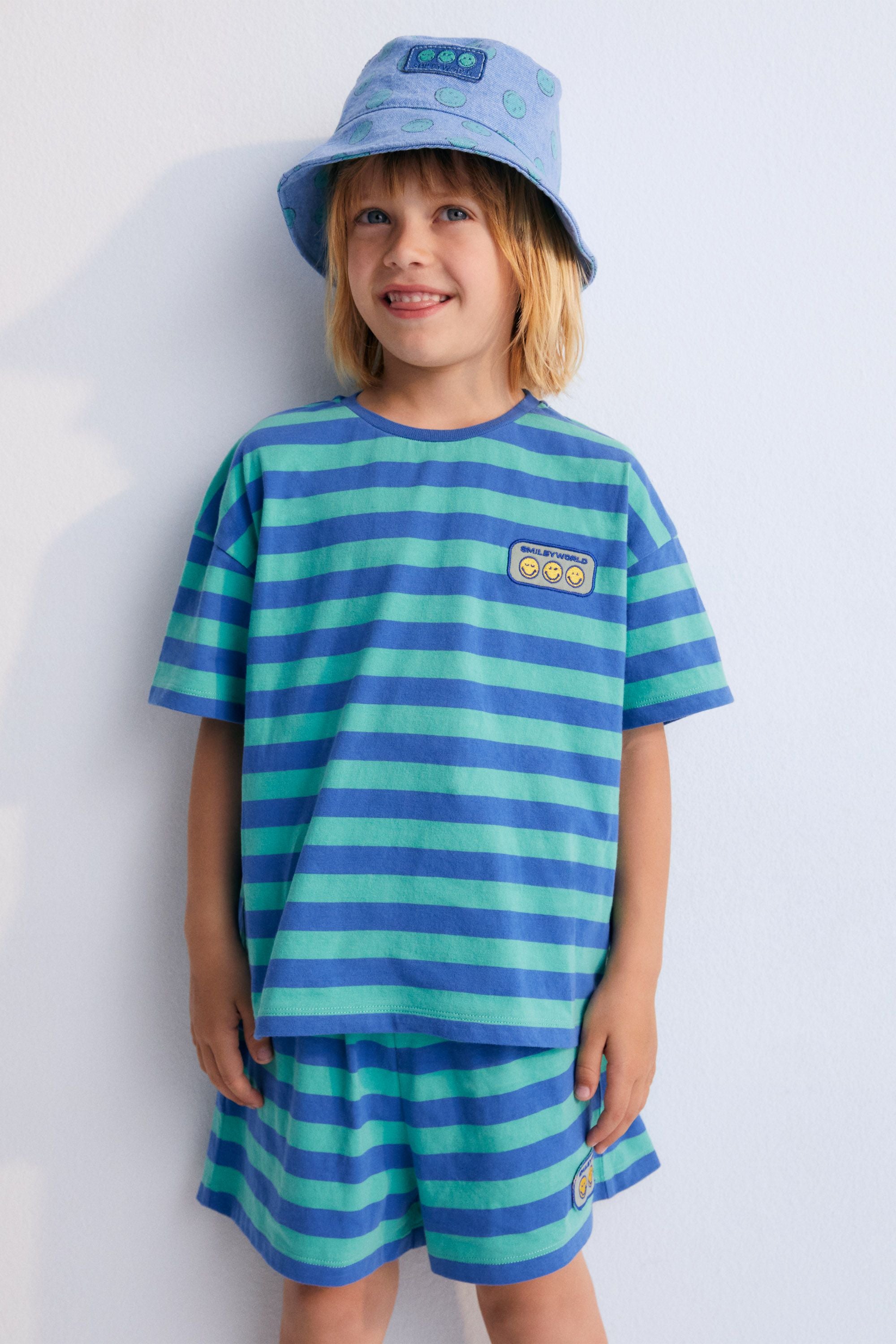 Shorts with fun bicolor stripes, elastic waistband with a drawstring, and a matching SMILEYWORLD patch. Perfect to combine with the matching T-shirt. Spring Summer Collection. The New Society. 