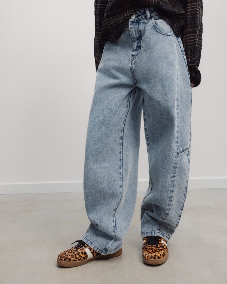 The TNS Denim Teen Curved Trouser explores contemporary denim through a sculptural curved silhouette, where considered pattern cutting creates effortless volume and movement.