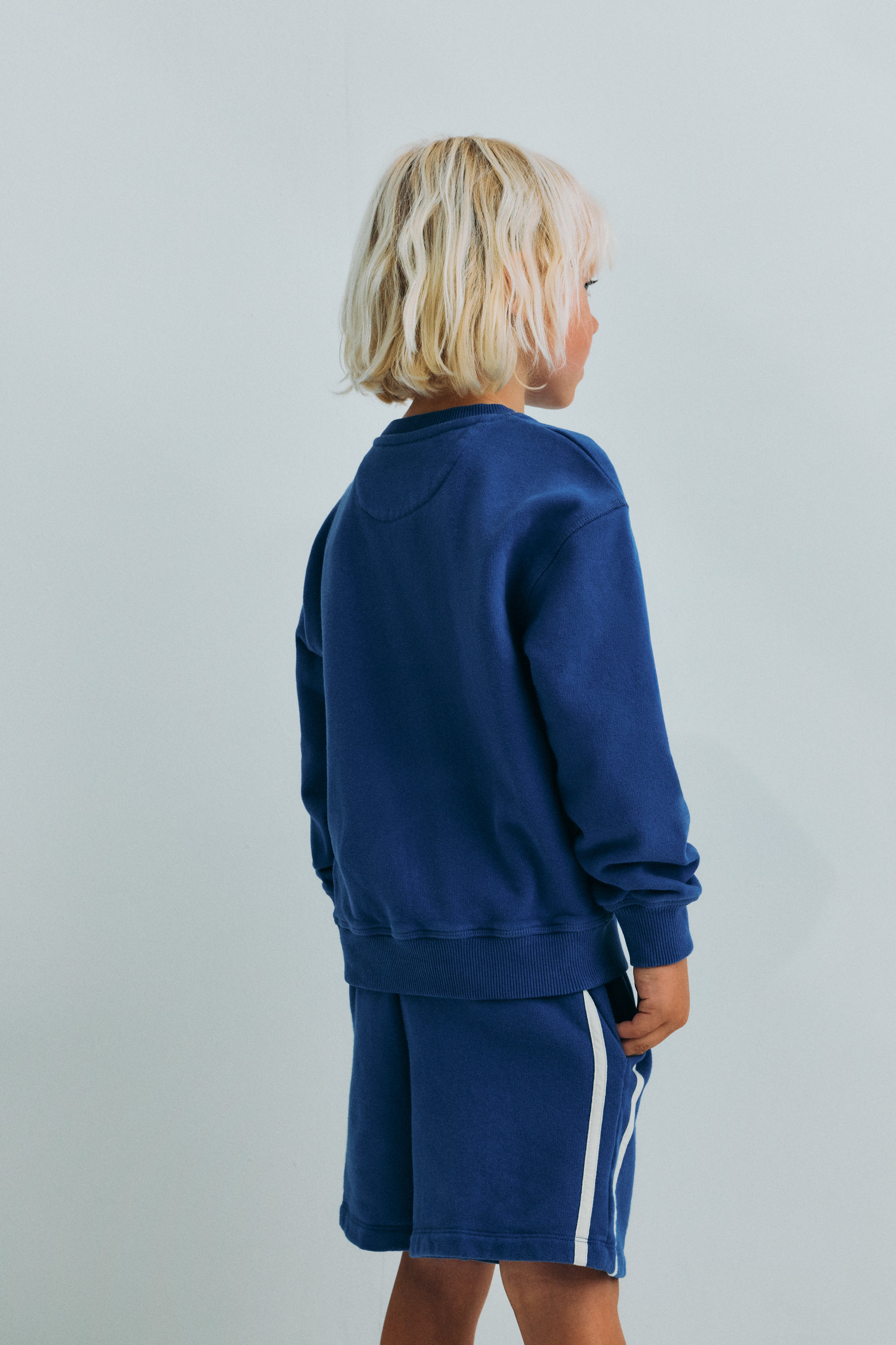 Kids’ blue bermuda shorts made from soft, lightweight fabric for all-day comfort and easy movement. 