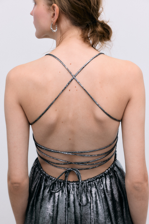 A striking dress crafted in shimmering silver fabric, featuring a fitted waist and elegant front ruching for a flattering silhouette. 