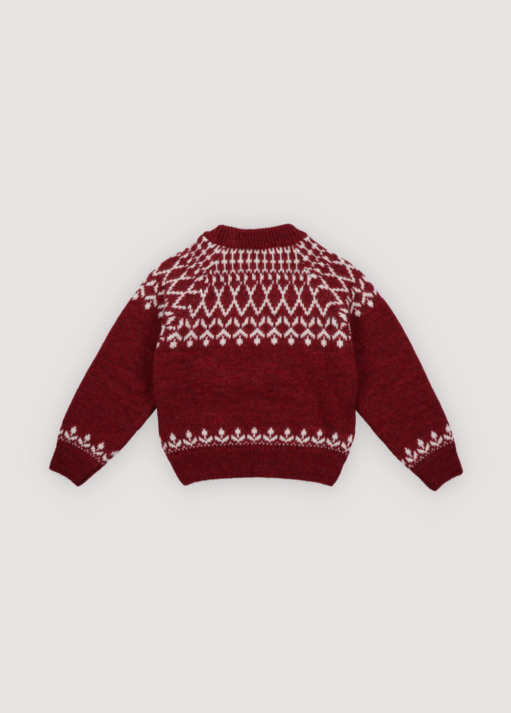 A cozy knitted jumper in a festive plum color, featuring a charming white pattern across the chest, sleeves, and hem. Soft, warm, and gently stretchy, it keeps little ones comfortable all day. With a relaxed fit for easy movement, it’s perfect for layering over shirts or dresses and ideal for holiday gatherings or capturing seasonal memories in style.