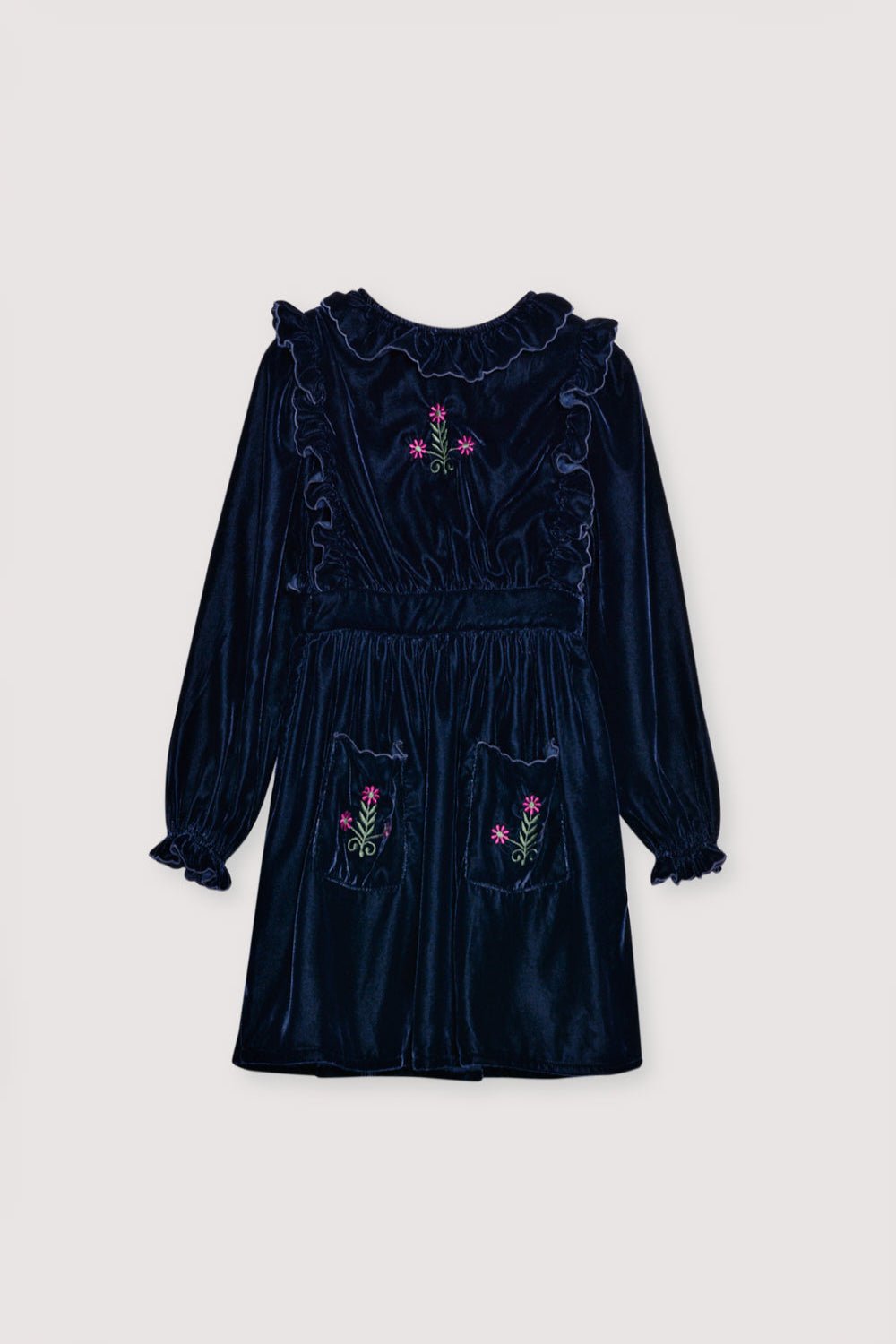 Velour dress with a fitted waist, featuring embroidery detail on the chest and two embroidered pockets on the skirt. It is finished with ruffles at the cuffs and opens at the back with ruffled details.  The dress has cotton lining in tone. 