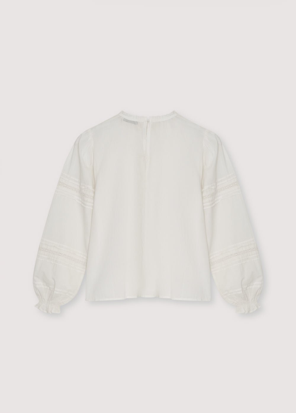 Bluse im romantischen Stil mit einer vorderen Passe aus Spitze und Rüschen sowie Spitzendetails an den Ärmeln. Es verfügt über einen runden Ausschnitt mit einer kleinen Rüschenkante und eine Rückenöffnung mit Knopfverschluss.
