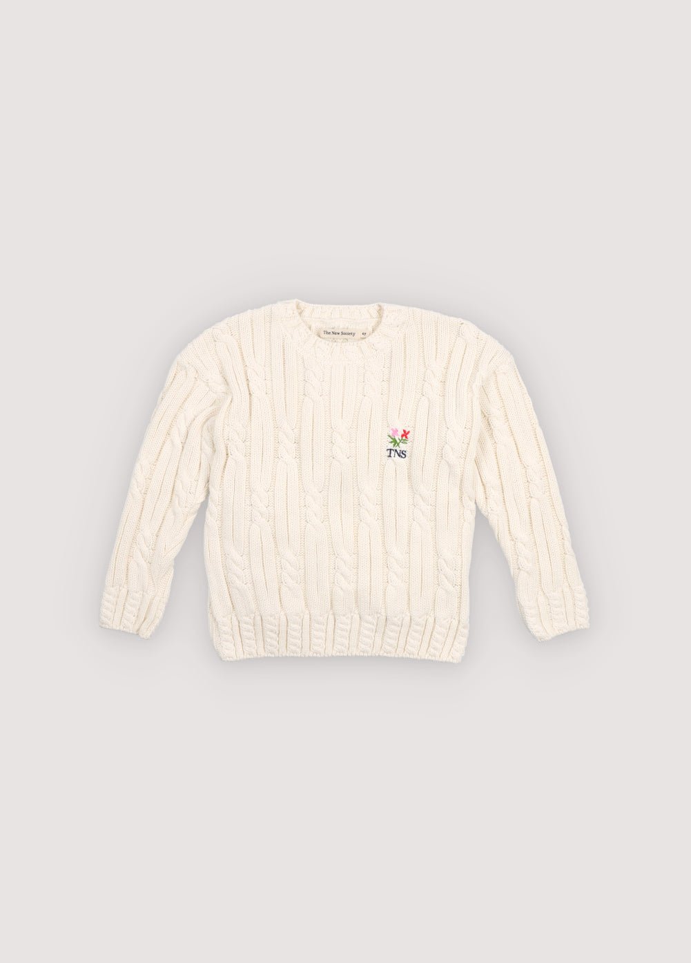 Cable knit sweater with&nbsp;subtle cable details on the collar, cuffs, and hem, featuring a playful floral branded embroidery on the chest.