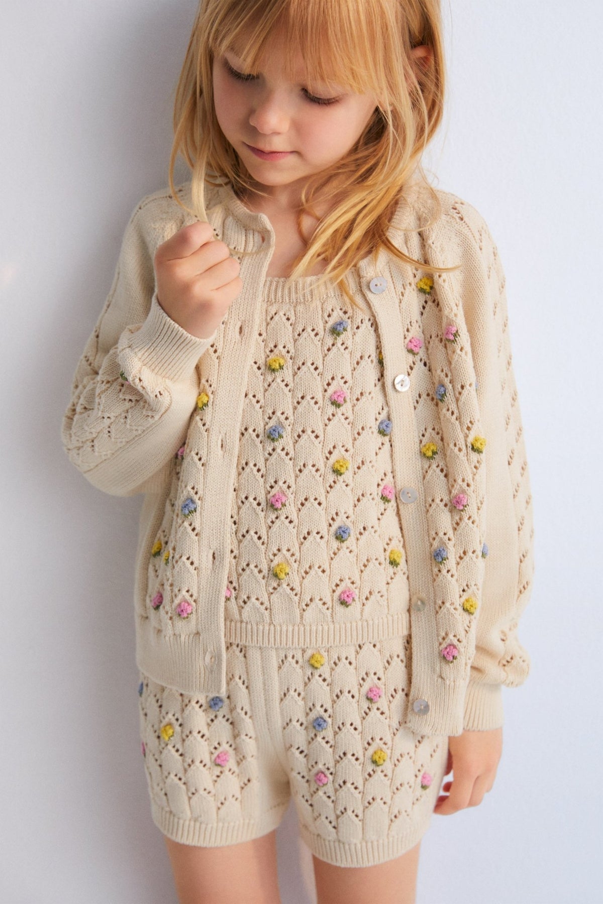 Cardigan with structure and flower details. It has a wooden button opening. Perfect to combine with the marching short and top. 