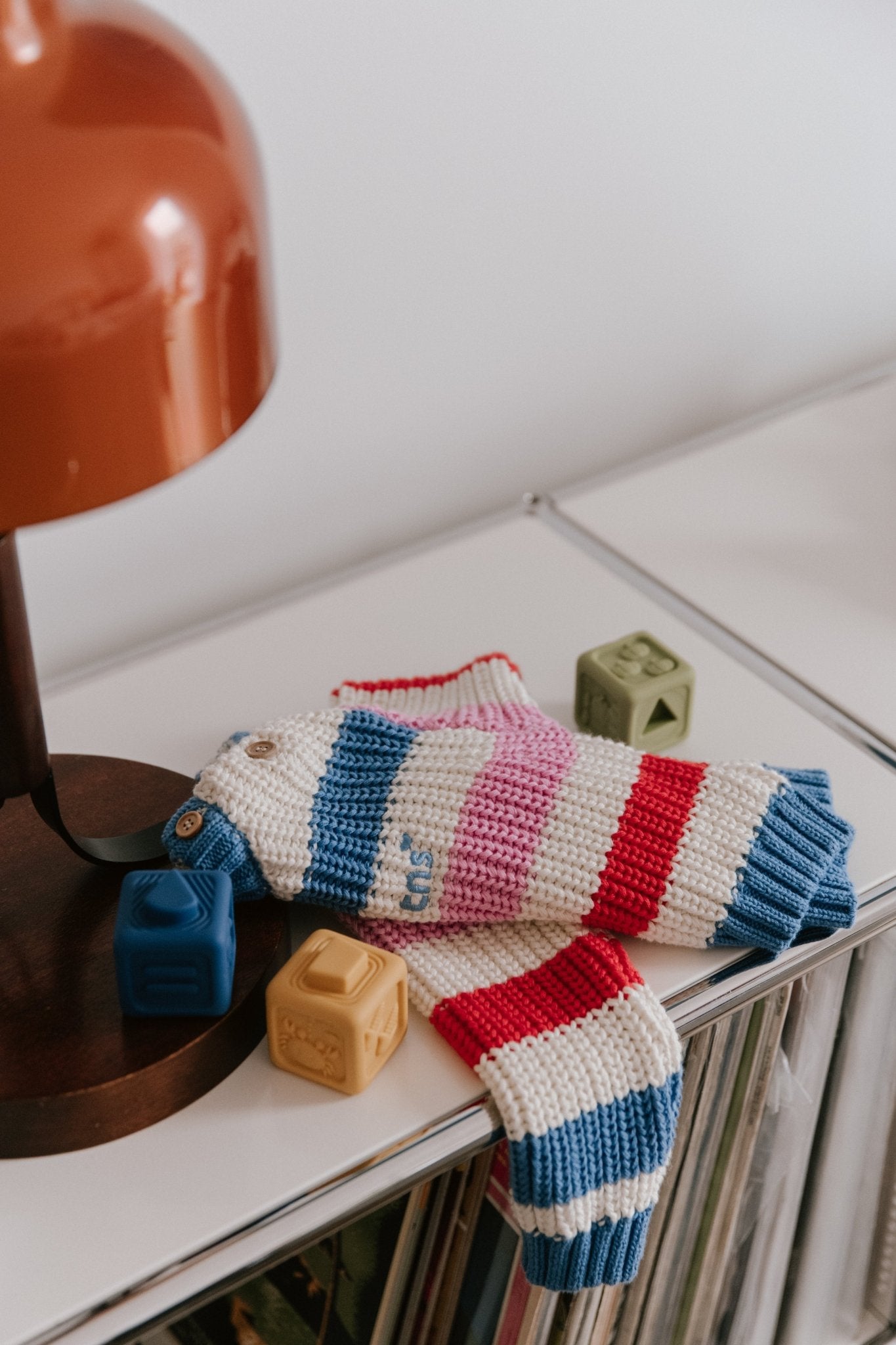 爽やかで夏らしいカラーと胸元の魅力的な刺繍ロゴディテールが特徴のベビーストライプコットンニット。