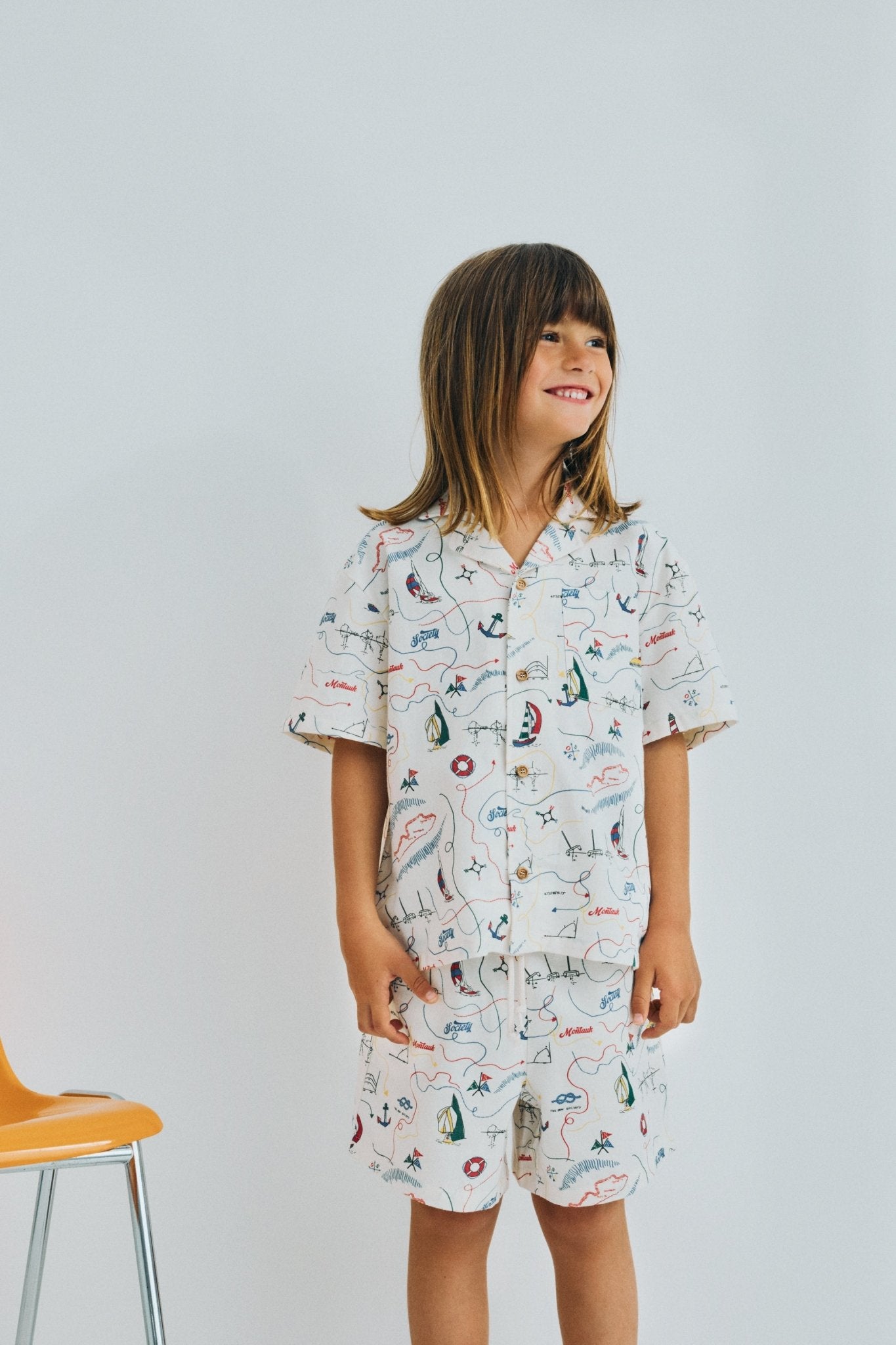 Short sleeve shirt in&nbsp;soft cotton featuring a unique multicolor map print and a front button closure with wooden buttons. 