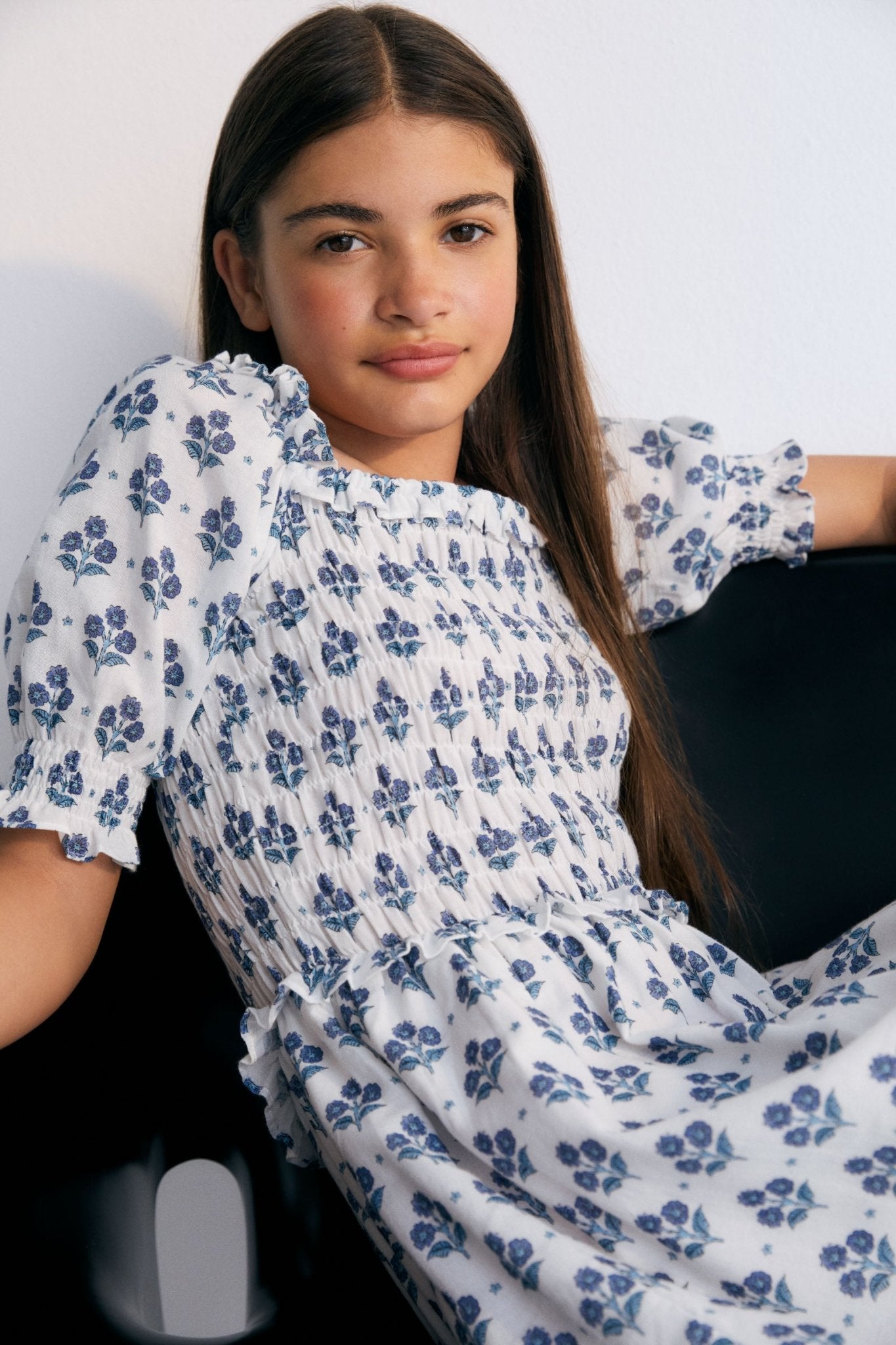 Eleni Dress in 100% cotton muslin fabric with our hyacinth print. The dress features a square neckline with smocking all over, puffed sleeves with smocking and a final ruffle, and a skirt with lots of volume.