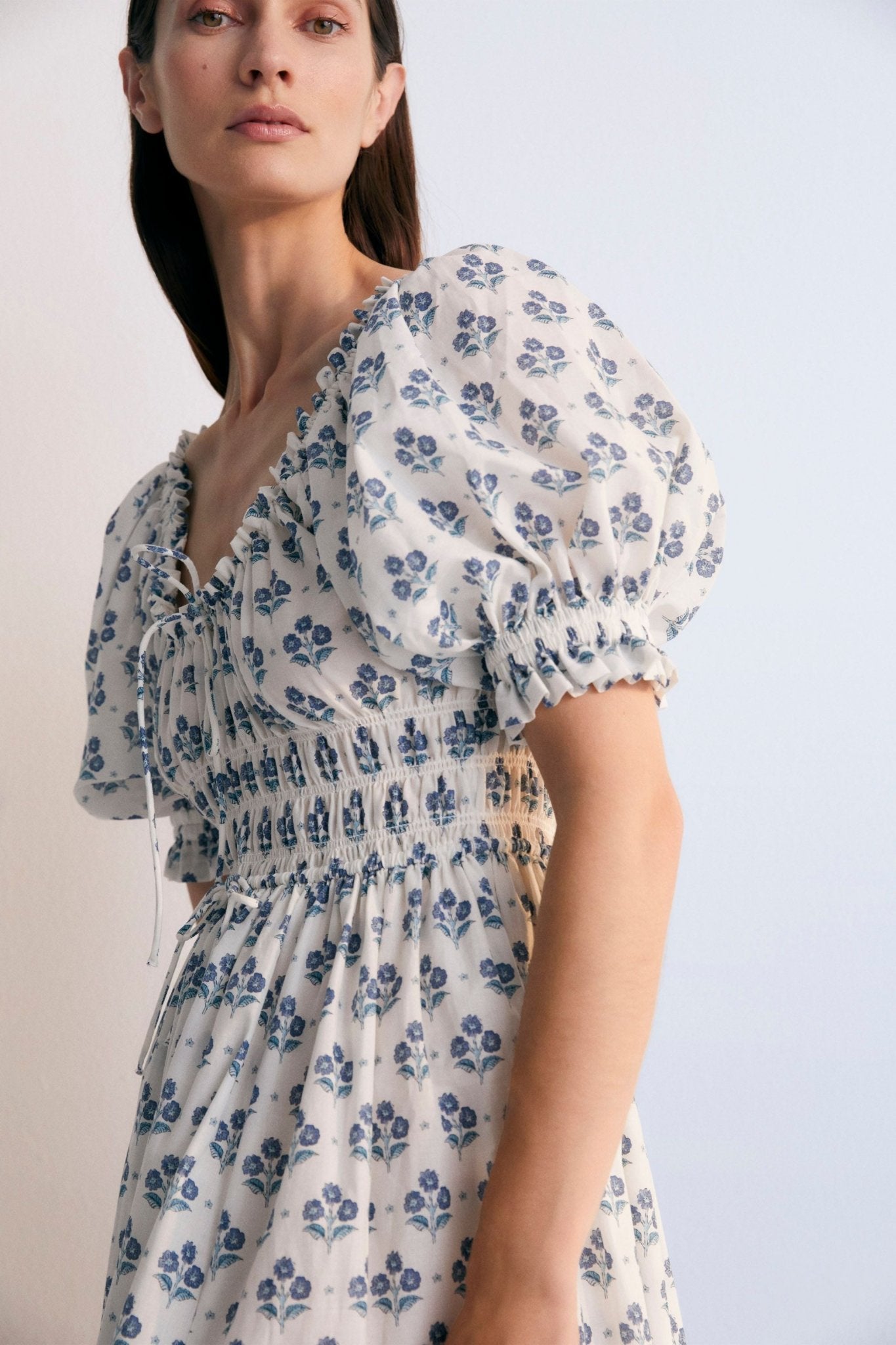 Eleni Woman Dress, our bestseller now featuring our Hyacinth print in 100% cotton poplin fabric. V-neck, elasticized, puff sleeves, and midi length. Spring Summer Collection. The  New Society.