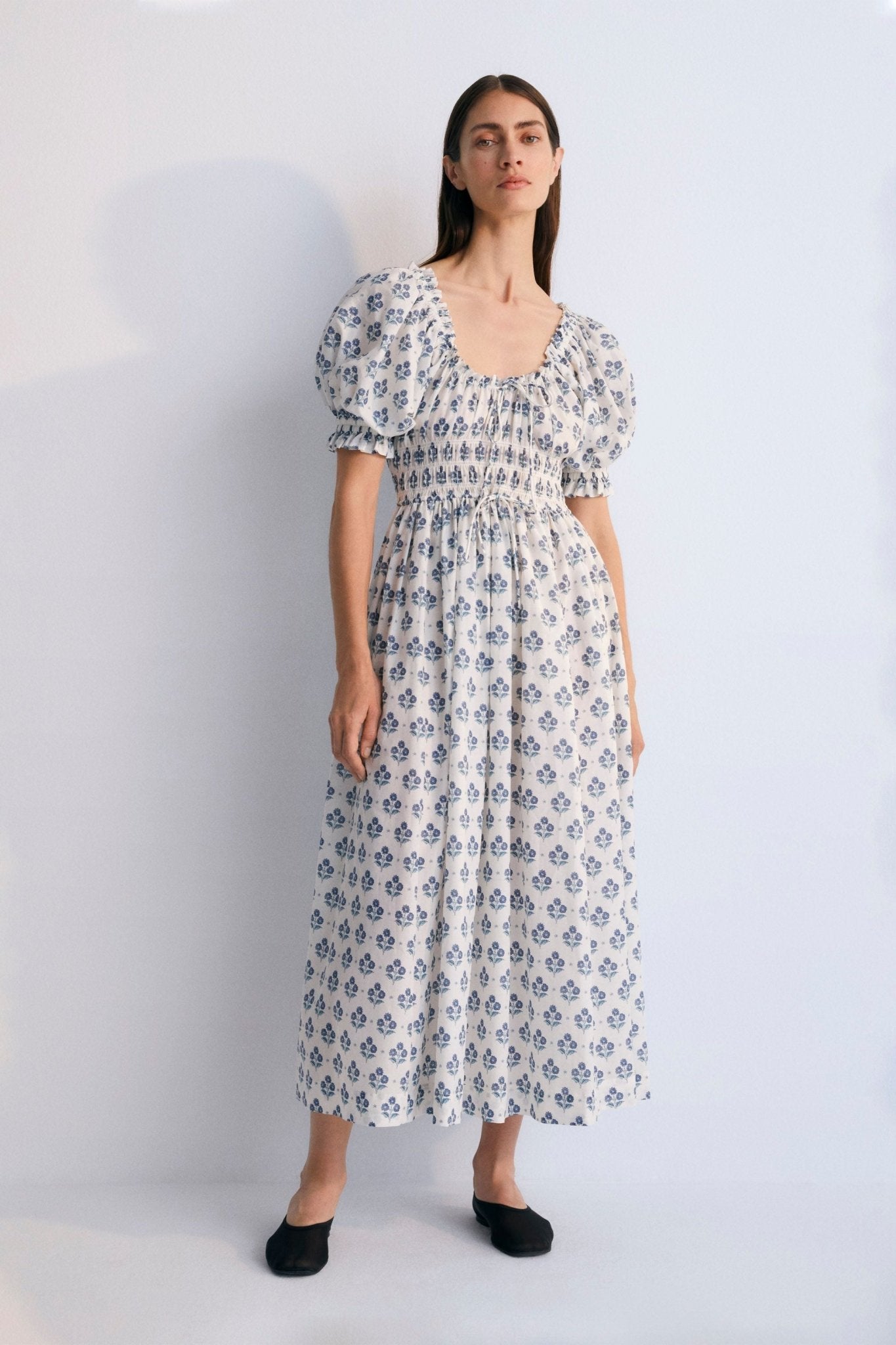 Eleni Woman Dress, our bestseller now featuring our Hyacinth print in 100% cotton poplin fabric. V-neck, elasticized, puff sleeves, and midi length. Spring Summer Collection. The  New Society.