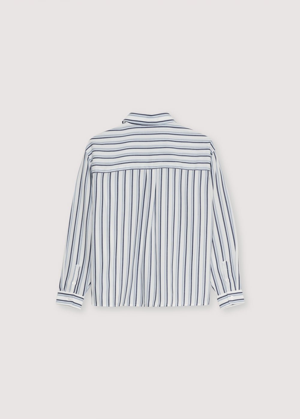 Camisa de rayas tencel en tonos azulados con puños y abertura con botones en el mismo tono. Tiene un bolsillo de parche en la parte delantera. Tiene una bufanda a juego de la misma calidad.