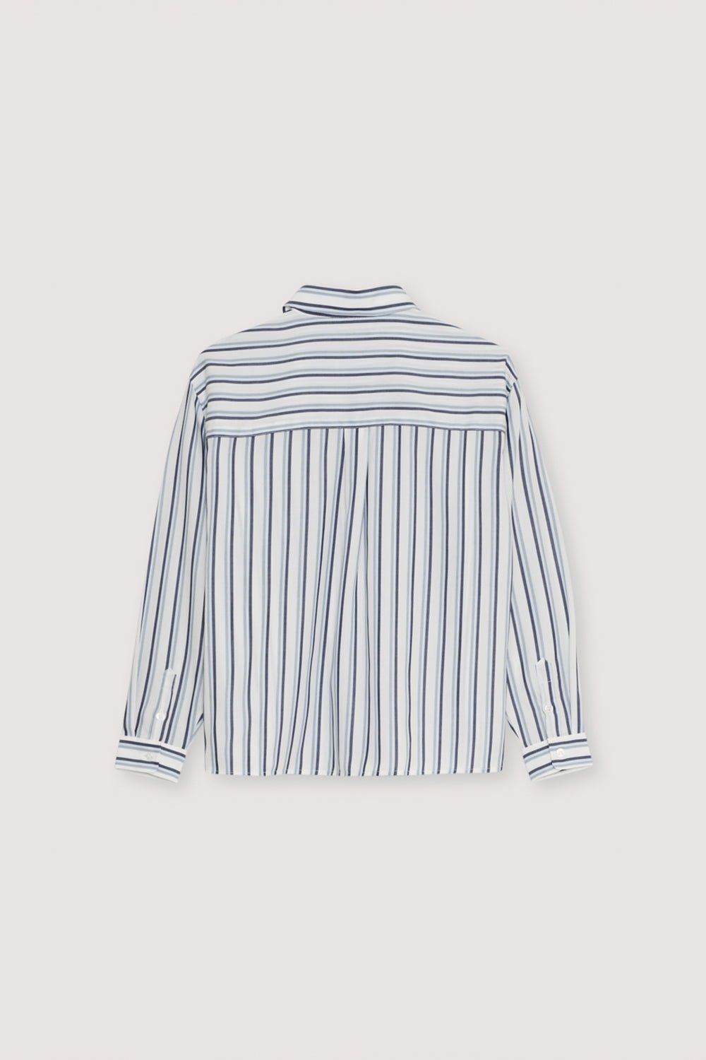 Chemise rayée en Tencel dans les tons bleutés avec poignets et ouverture boutonnée du même ton. Il comporte une poche plaquée sur le devant et une écharpe assortie de la même qualité.