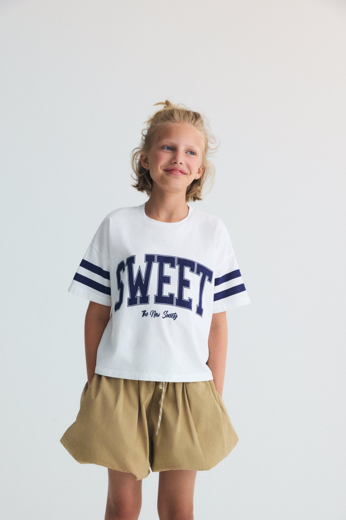 Short de style ballon en coton doux avec une taille réglable par cordon et un élastique griffé emblématique, offrant une silhouette confortable et moderne.