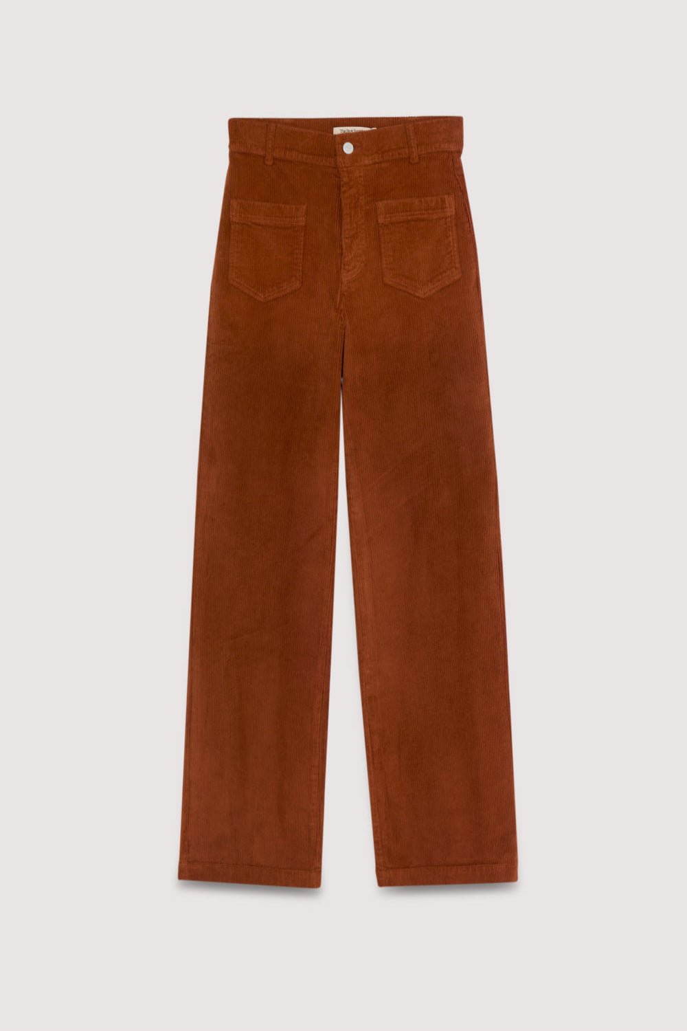 Pantalon en velours côtelé marron sur fond gris clair. Collection Femme The New Society