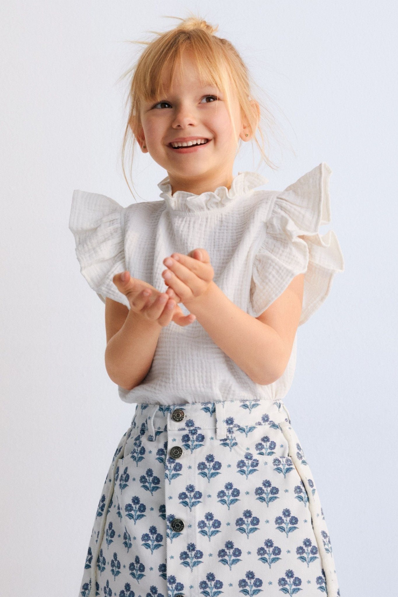 Short denim skirt with a lovely stamp print and a front slit with branded button closure. Spring Summer Collection. The New Society.