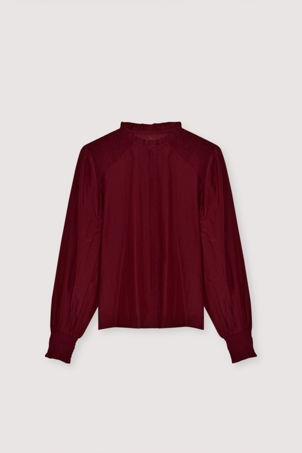 Une blouse en batiste raffinée confectionnée dans un tissu léger de haute qualité. Conçu avec de délicats smocks sur les épaules et les poignets, il ajoute une texture subtile et une touche féminine élégante. Le devant présente une patte cachée propre pour une finition élégante et minimaliste. Disponible en couleur prune fantaisie, parfait pour un style quotidien sans effort ou des looks raffinés.