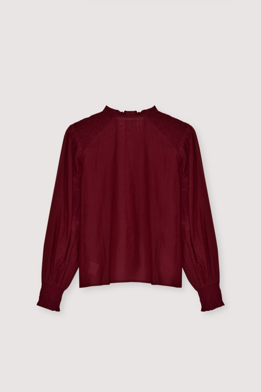 Une blouse en batiste raffinée confectionnée dans un tissu léger de haute qualité. Conçu avec de délicats smocks sur les épaules et les poignets, il ajoute une texture subtile et une touche féminine élégante. Le devant présente une patte cachée propre pour une finition élégante et minimaliste. Disponible en couleur prune fantaisie, parfait pour un style quotidien sans effort ou des looks raffinés.