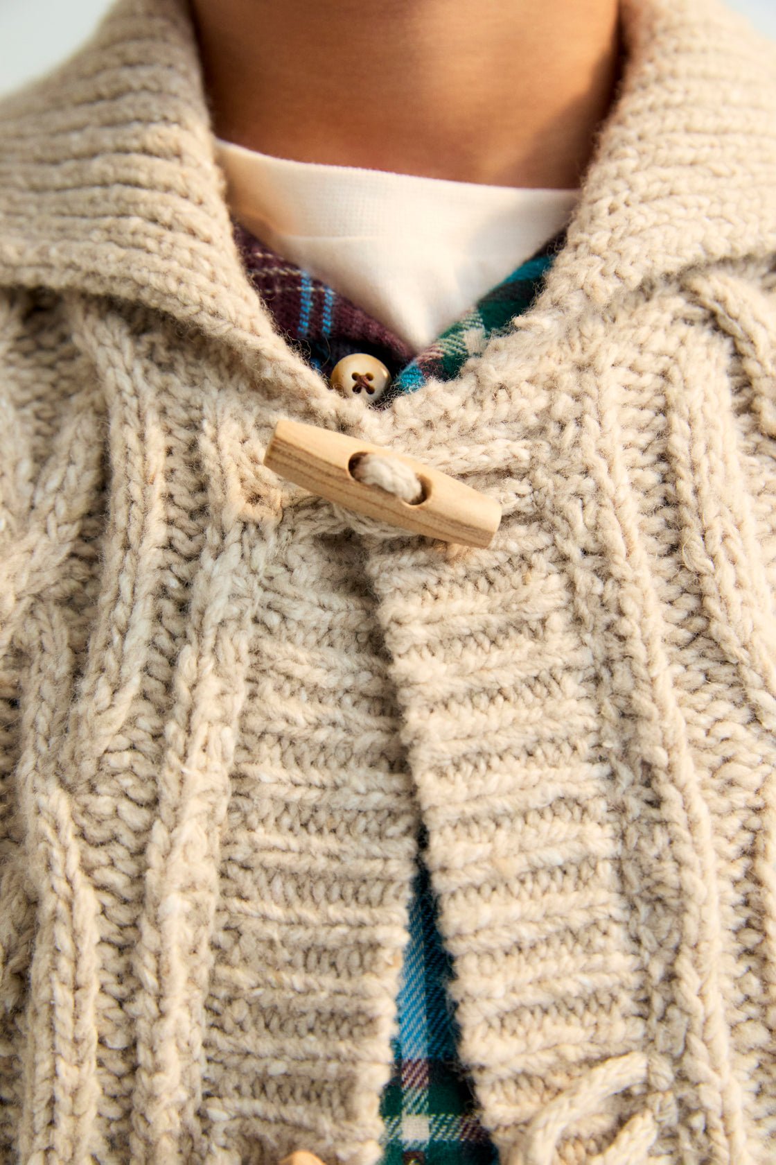 Strickjacke mit geripptem Kragen, Bündchen und Saum. Verfügt über eine vordere Öffnung mit Holzverschlüssen. Hergestellt aus recycelter Wolle.